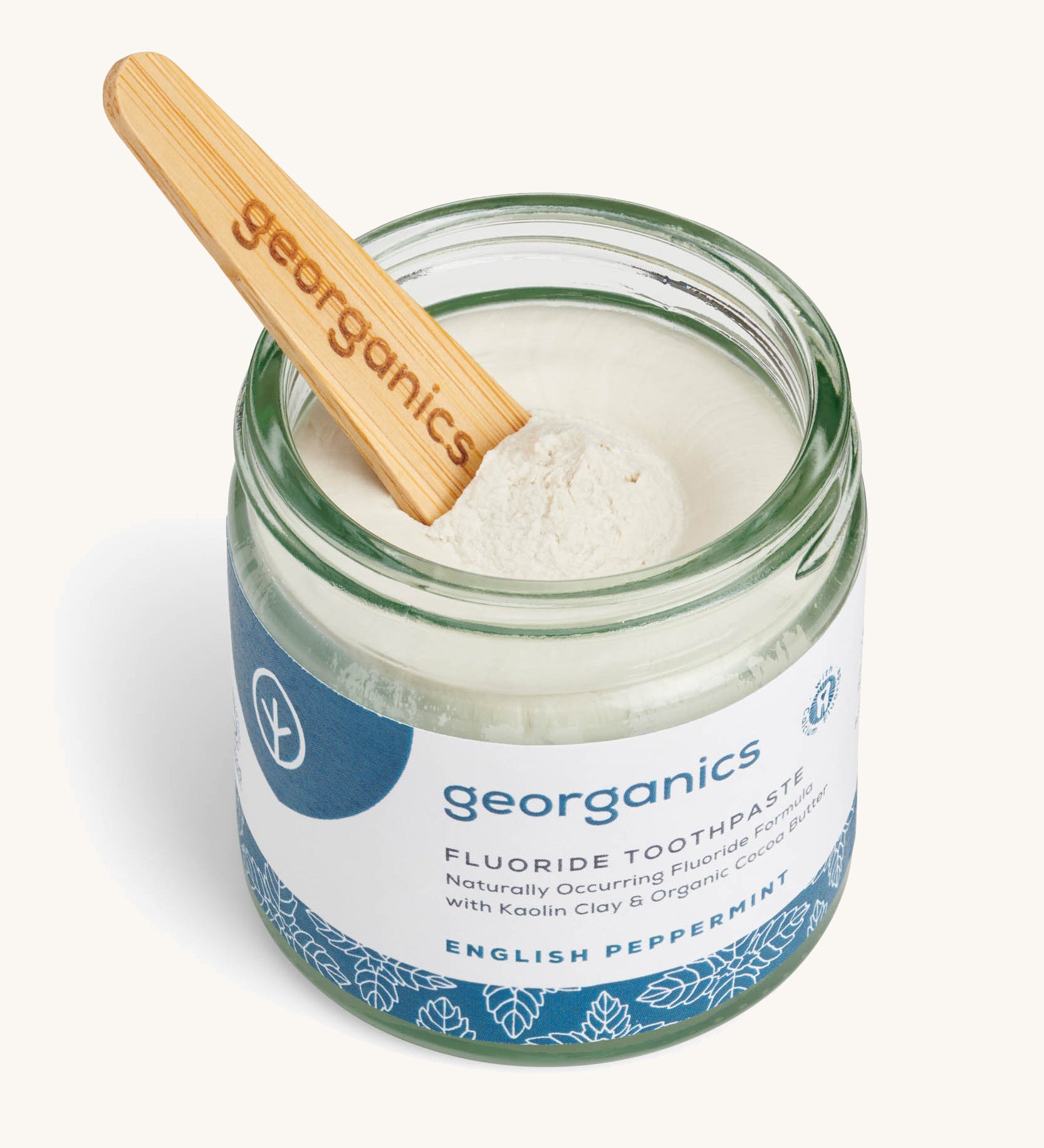 A opened jar of the English peppermint fluoride toothpaste with a wooden spatula dipped in.