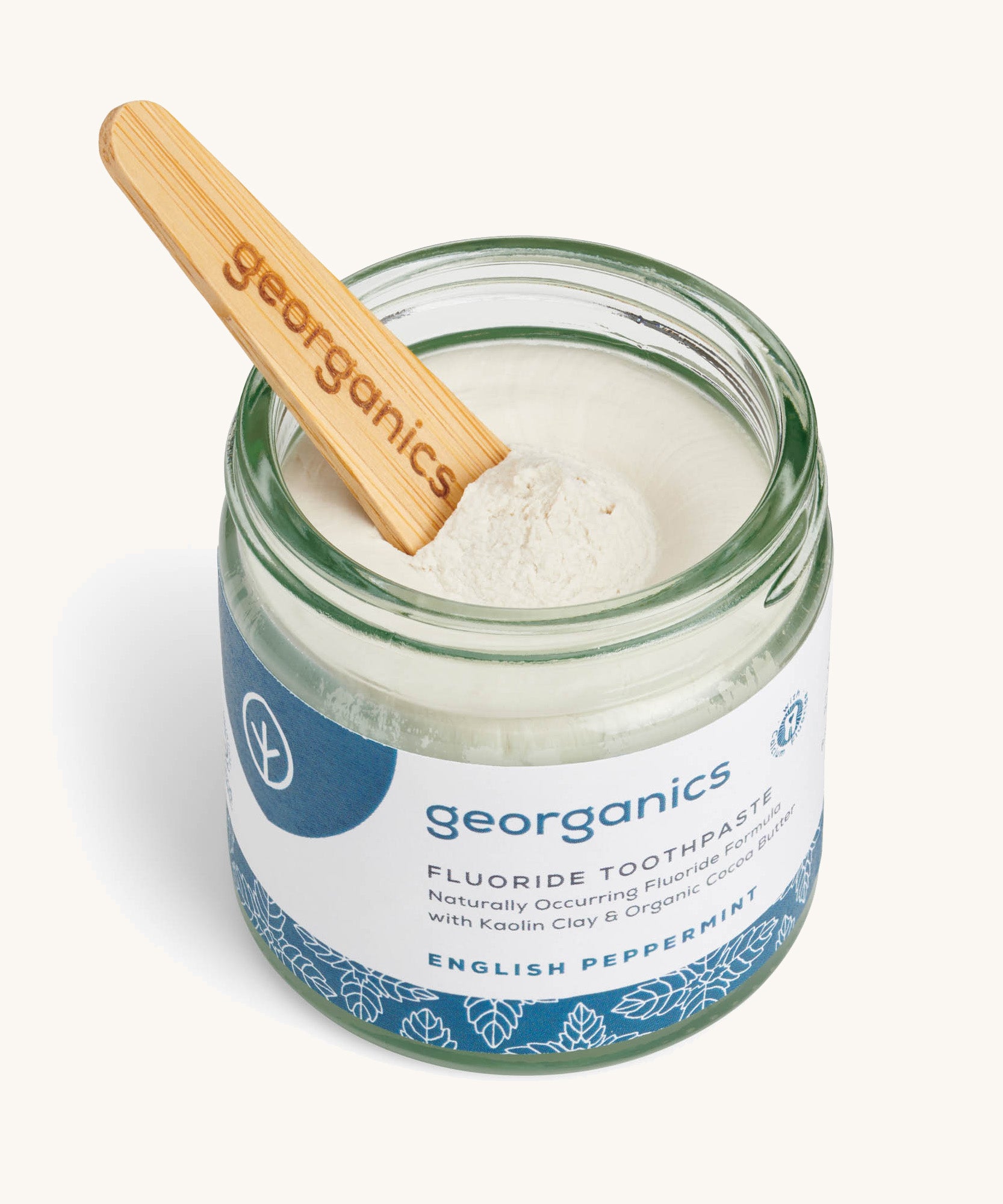 A opened jar of the English peppermint fluoride toothpaste with a wooden spatula dipped in.