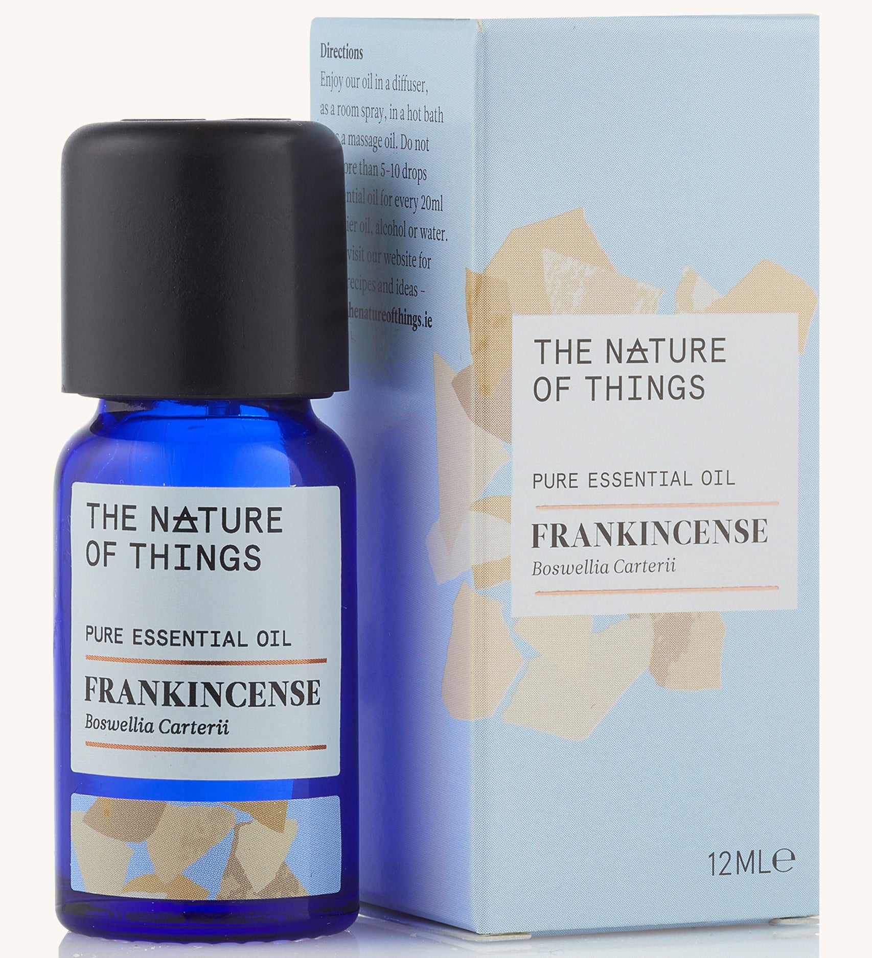 Frankincense pure essential oil in a blue glass bottle in front of a decorative blue cardboard box.