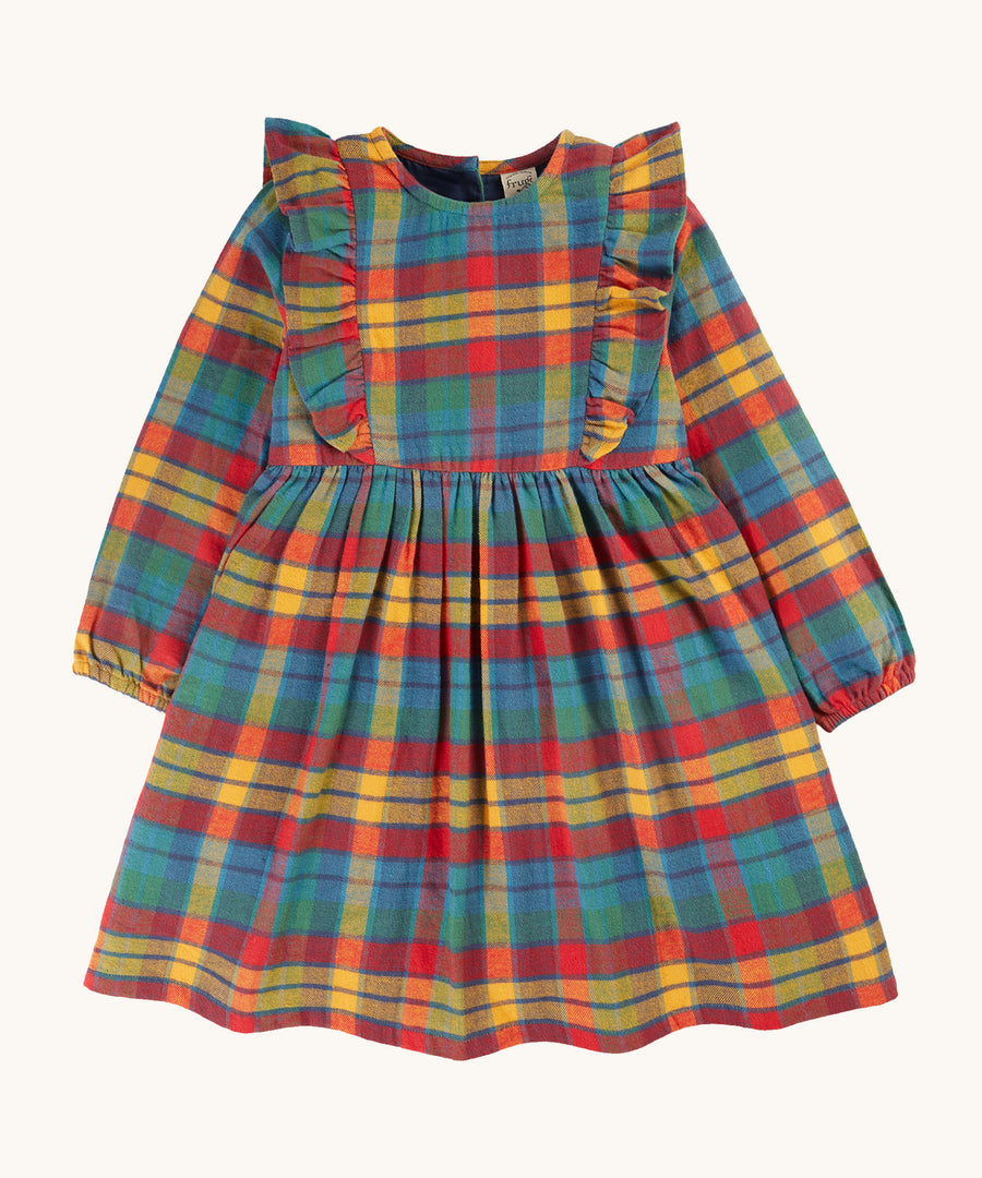 Frugi Agnes Dress - Merry Rainbow Check. An organic cotton dress, with long sleeves and, frilly detailing. In a rainbow check print in shades of red, yellow, green and blue