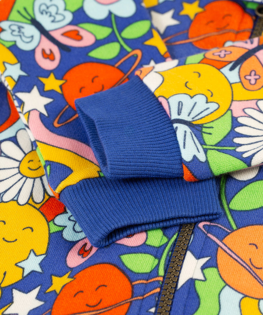 A closer look at the royal blue, elasticated ribbed wrist cuffs on the Frugi Snuggle Suit - Retro Happy. The image also shows the Retro Happy print and the zip on the snuggle suit