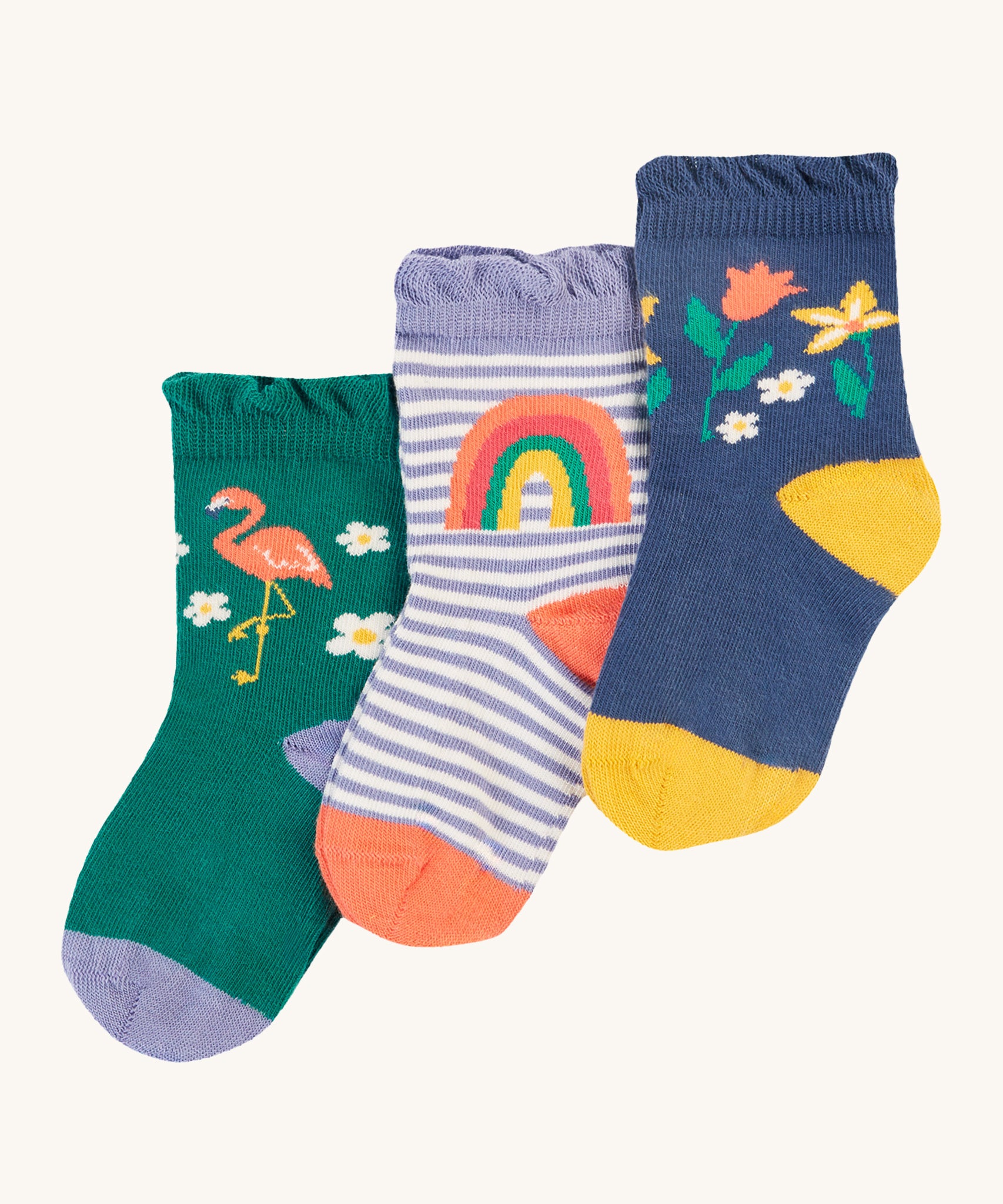 Frugi Freya Frilled Socks 3 Pack - Rainforest Friends. Organic Cotton frill socks in lovely 'Rainforest Friends' designs, one pair comes in navy with delicate flowers and yellow heels and toes, one green pair features a flamingo with lilac heels and cuffs, and the other comes in a lilac stripe with a rainbow on the ankles