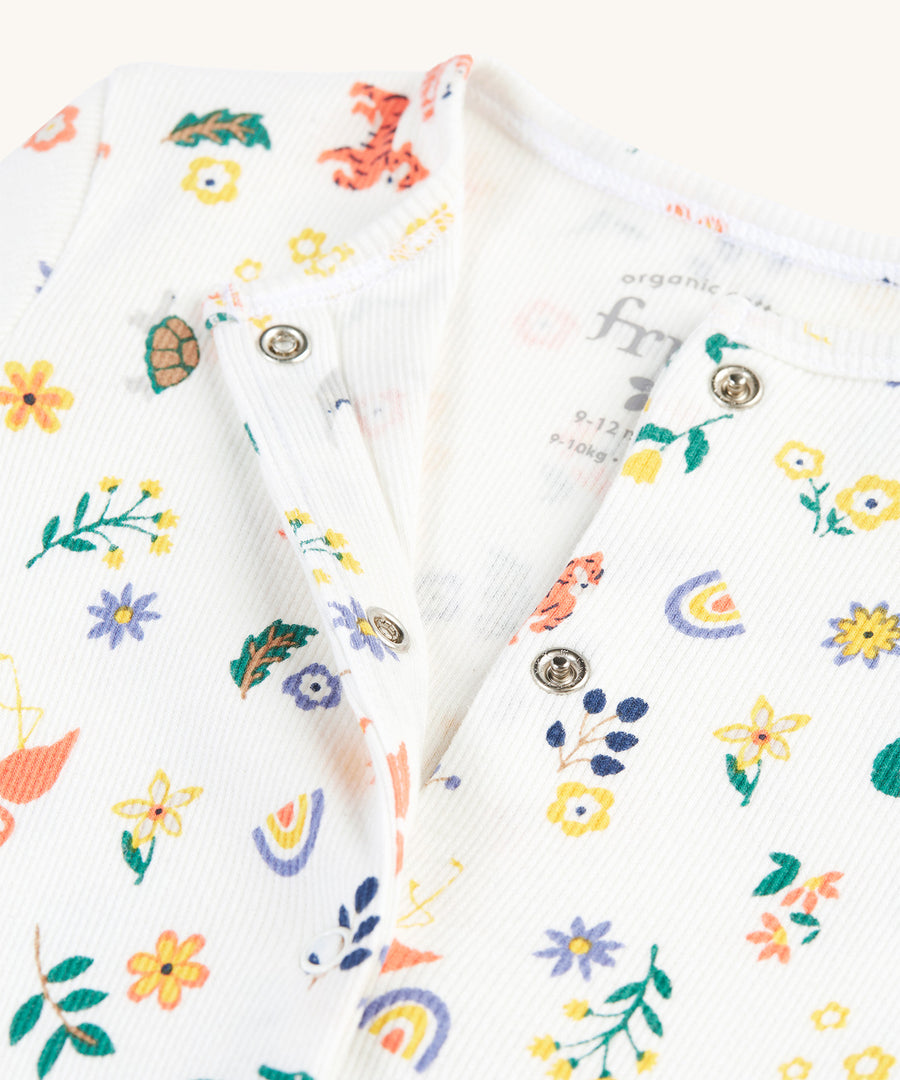 A closer look at the open babygrow and popper fastenings from the Frugi Reve Baby Gift Set - Better Together. The babygrow is in white cotton with delicate animal and flower/leaf prints