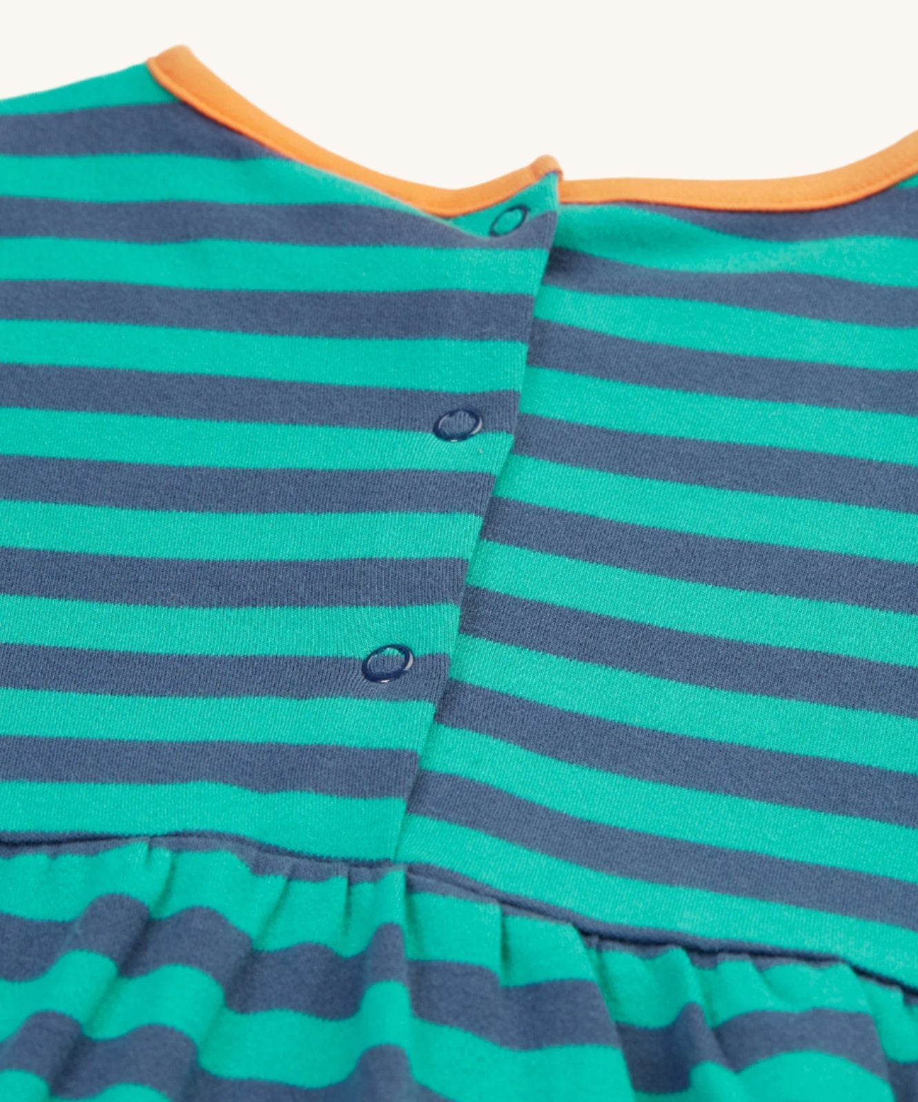 The back of the Frugi Dolcie Dress - Iguana Stripe/Tiger, showing the popper fasteners 