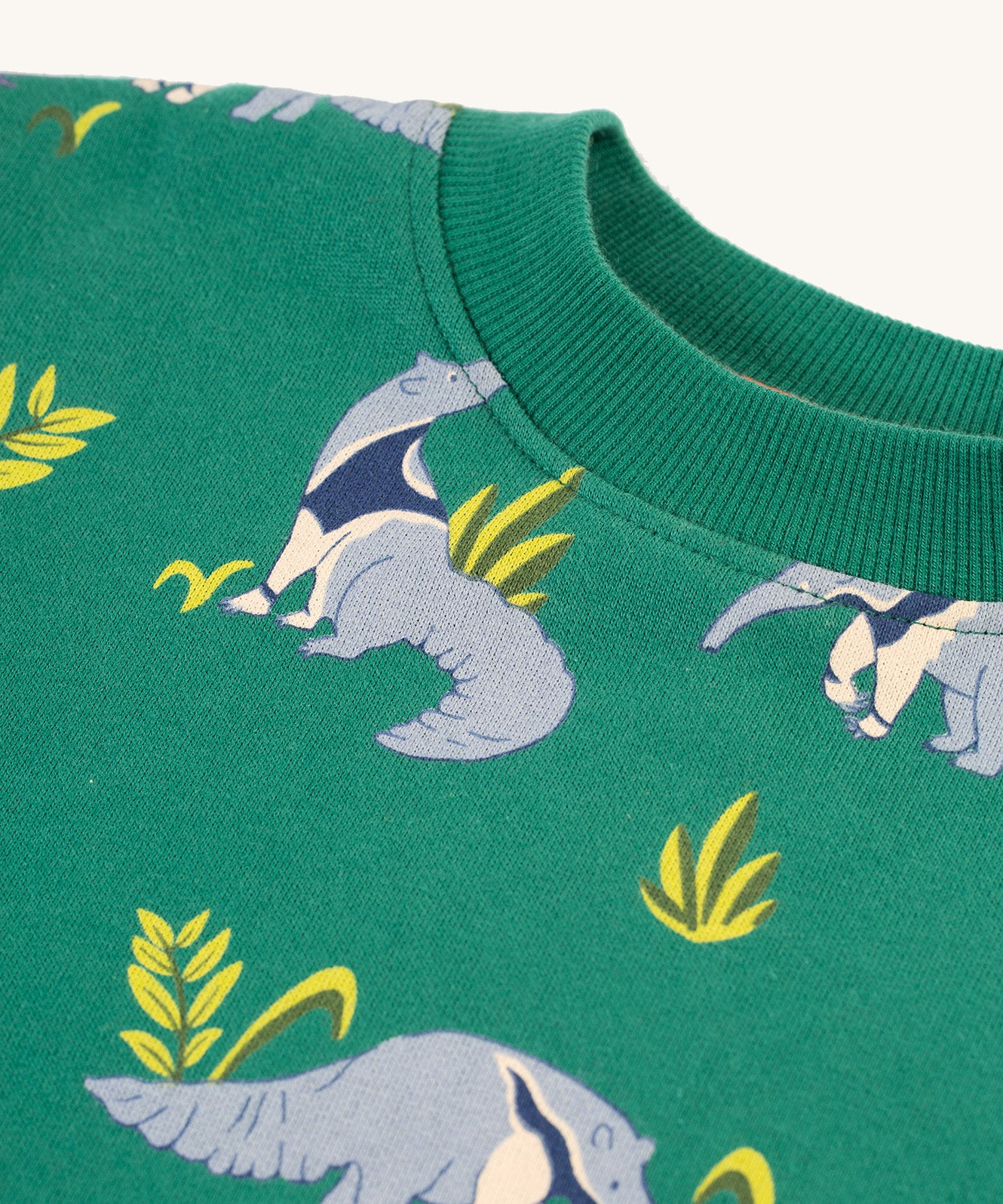 The elasticated rib neck collar on the Frugi Superb Sweatshirt - Anteater Parade. The image also shows the repeat anteater print on the sweatshirt