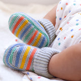 A closer look at the Frugi Briar Knitted Booties - Grey Marl Stripe, being worn by a baby