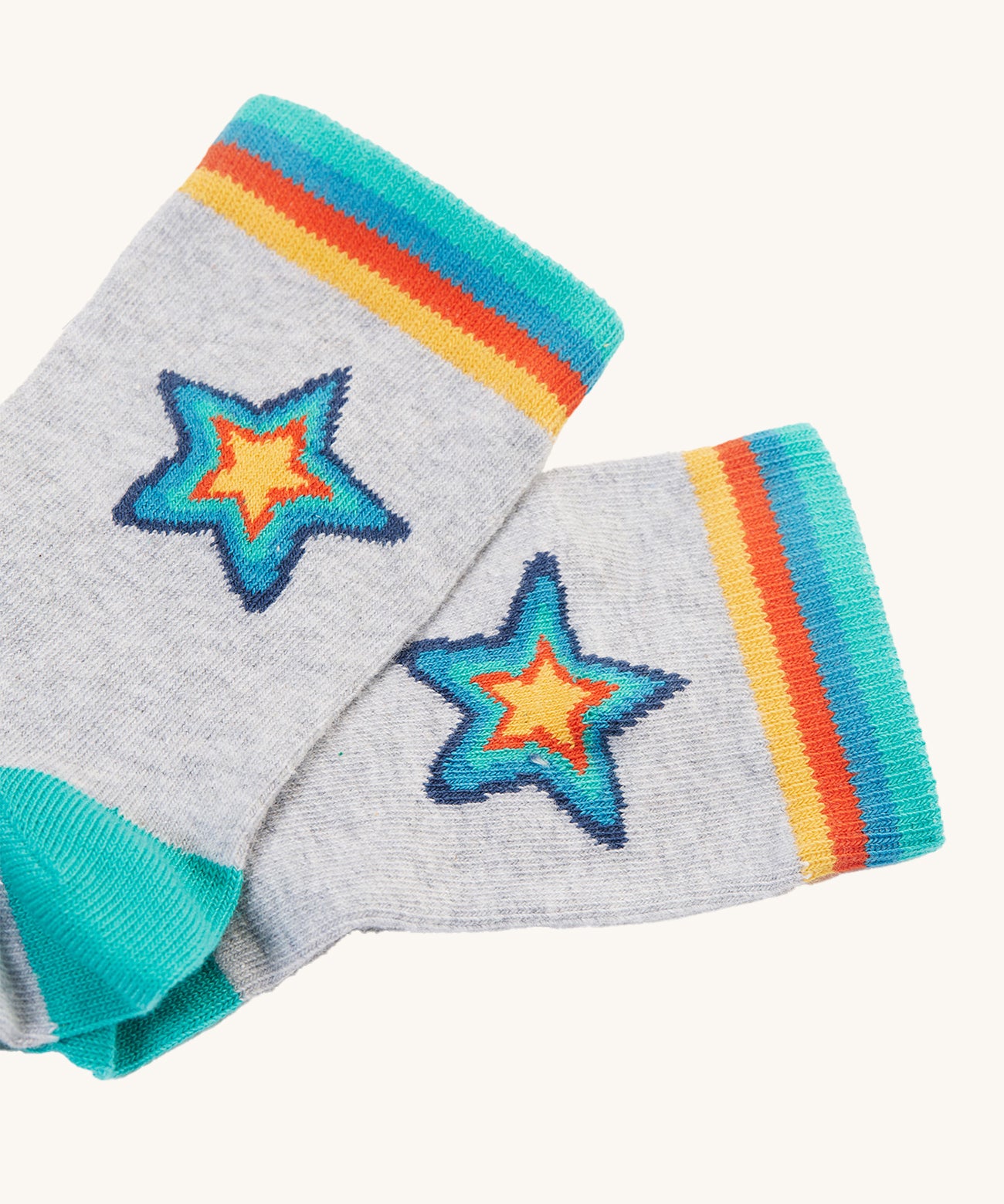 The grey pair of socks from the Frugi Rock My Socks - Stars 2 Pack. These grey socks have a rainbow star on them, and rainbow ankle cuffs