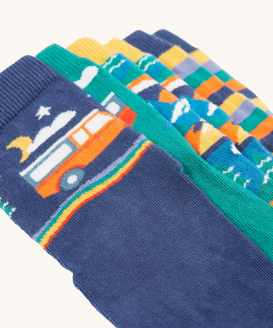 A closer look at the designs on the Frugi Rock My Socks 3 Pack - Alpine Adventures. The one showing at the front is a navy blue sock with a night time camper van print