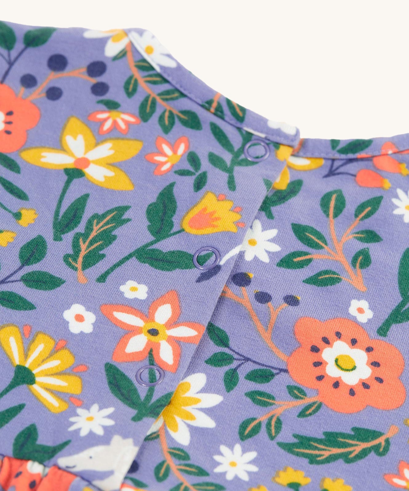 A closer look at the back of the Frugi Dee Dress - Rainforest Friends, showing the popper fastenings for easy on and off dressing 