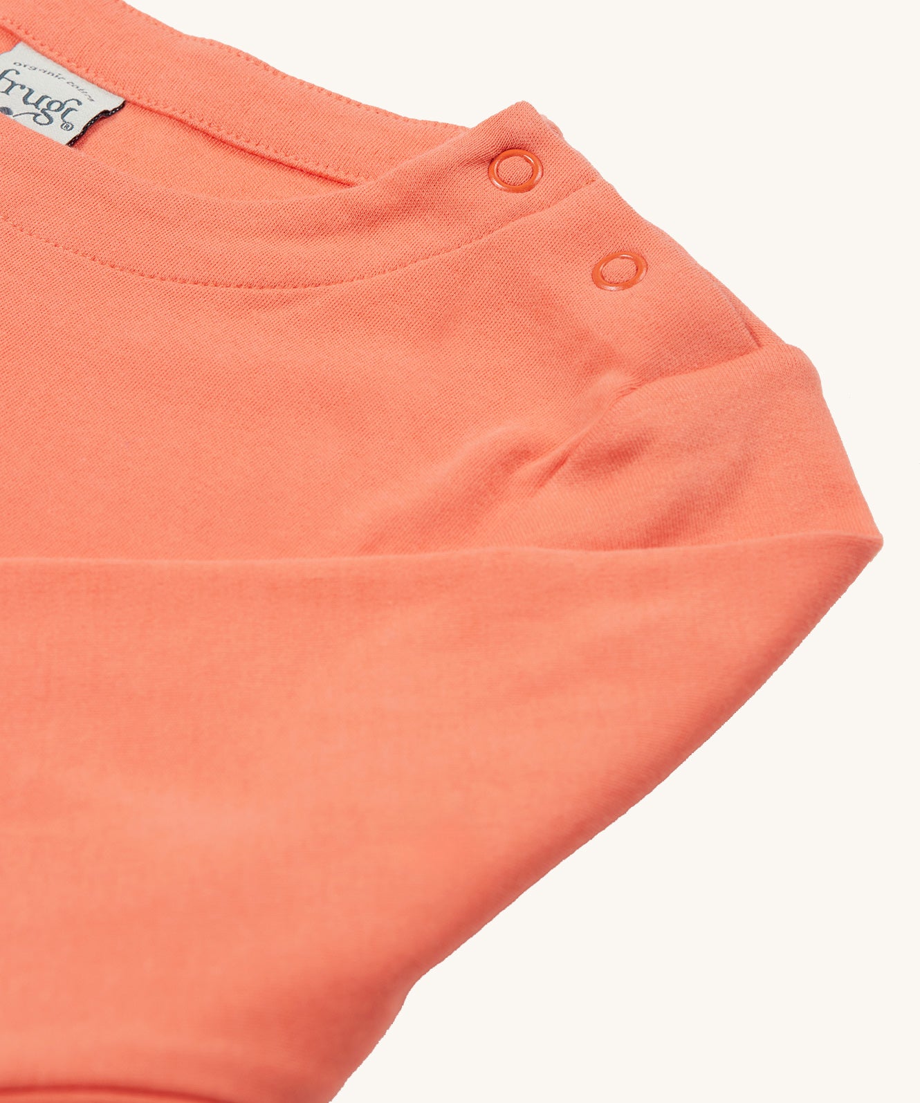 The popper fasteners on the shoulder of the Frugi Anna Applique Top - Cantaloupe/Fairy