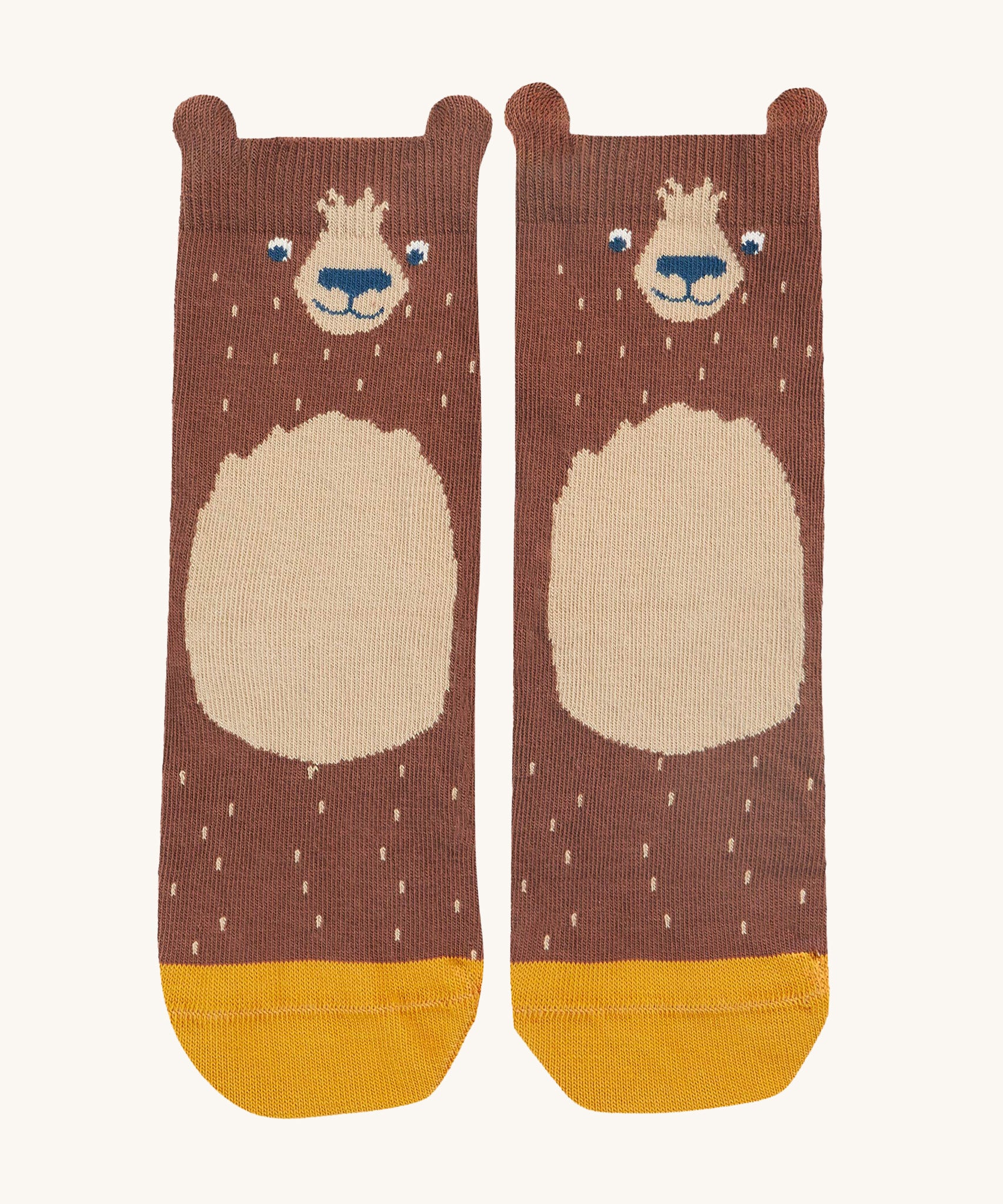 A closer look at the adorable bear print socks, from the Frugi Rock My Socks - Bear 3 Pack. The bear is dark brown with a small light brown tummy patch, a cute smiling face  and a yellow toe section at the bottom of the sock