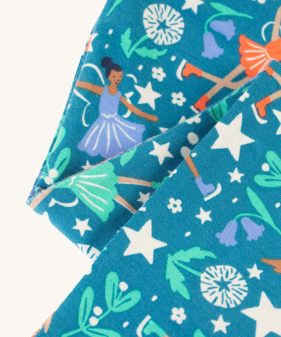 A closer look at the soft, organic cotton leggings in the Frugi Libby Printed Leggings - Enchanted Forest. A teal blue, organic cotton featuring little robins, stars, holly leaves, flowers, and fairy ballerinas.