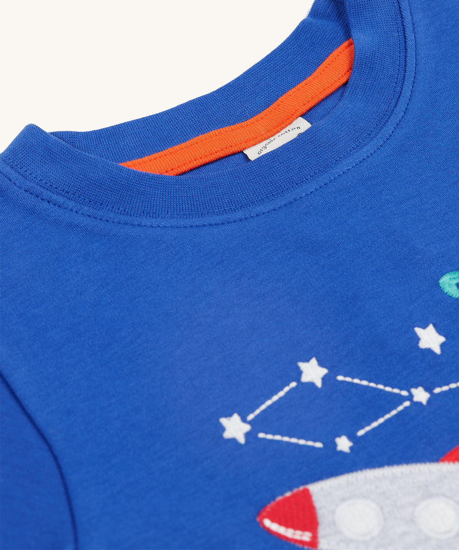 A closer look at the collar on the Frugi Little Creature Applique Top - Blue Tang/Rocket. Part of the space/rocket applique is showing at the bottom right of the image