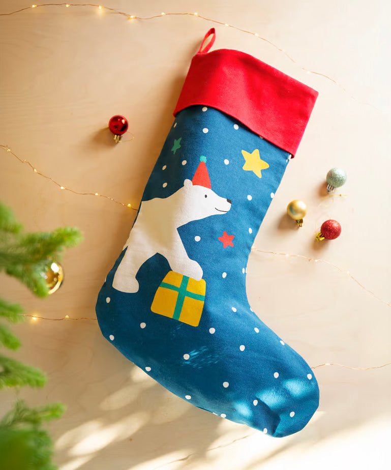 The Frugi Yuletide Stocking - Loch Blue/Polar Bear next to Christmas decorations