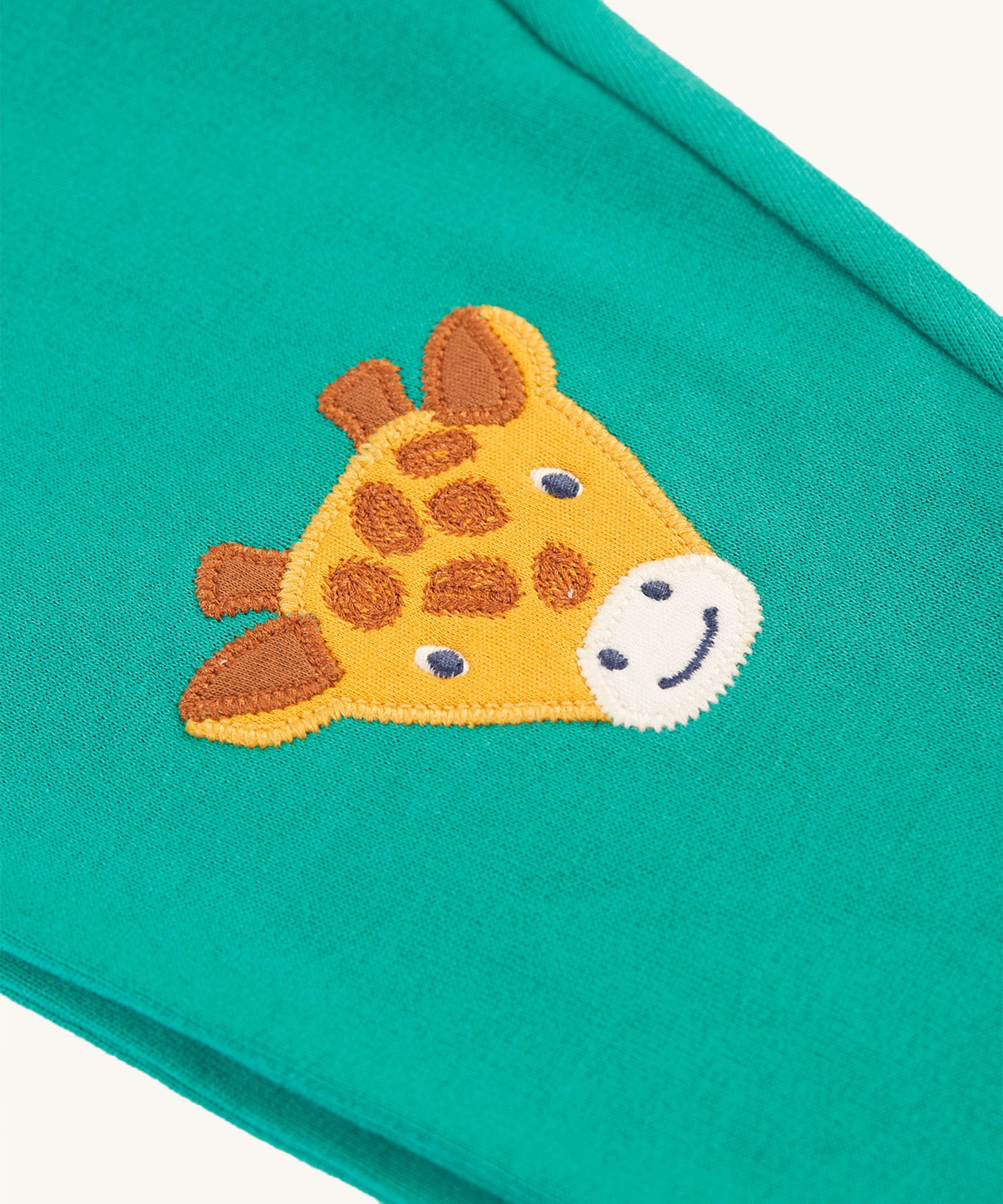 A closer look at the giraffe patch on the Frugi Character Crawlers - Iguana/Tiger