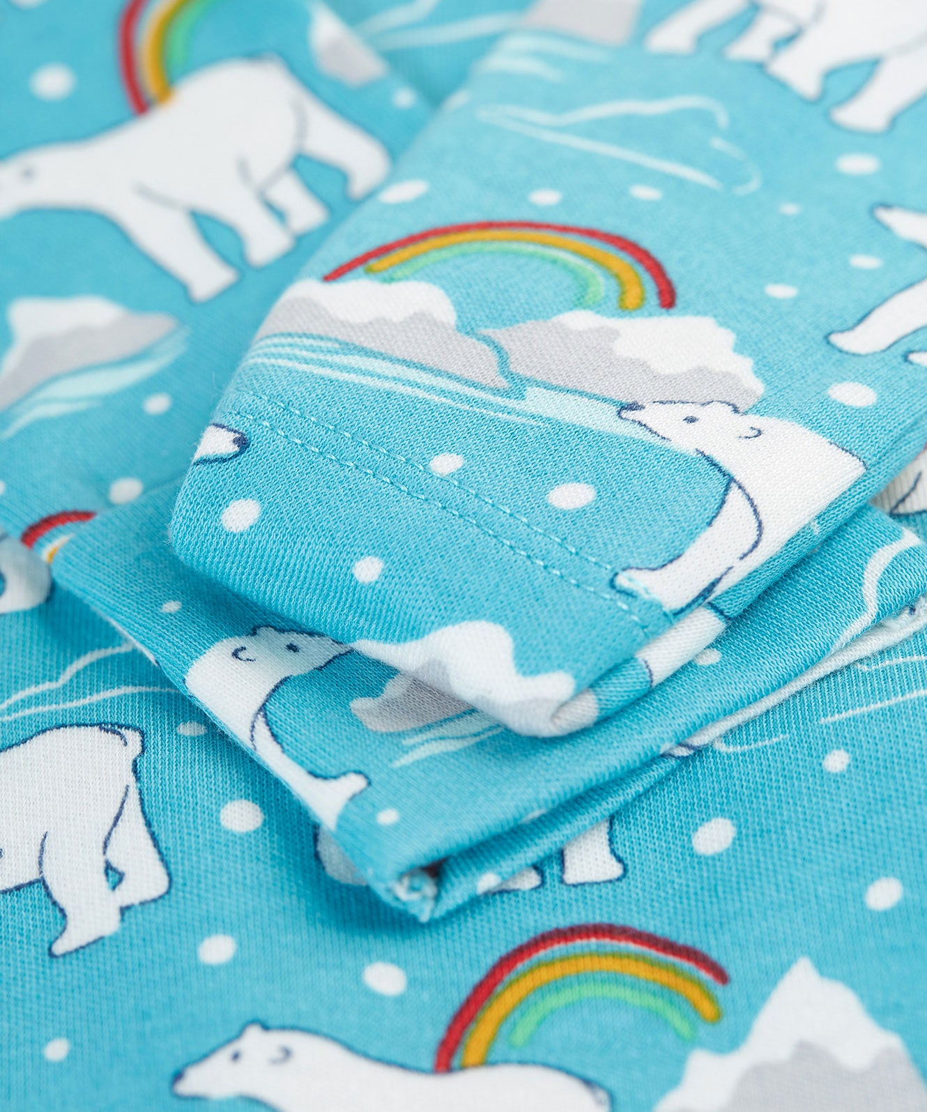 A close up of the scratch mitts which fold over the wrist cuffs on the Frugi Easy Dressing Babygrow - Winter Tails. The image also shows the Winter Tails, Polar Bear print on the babygrow