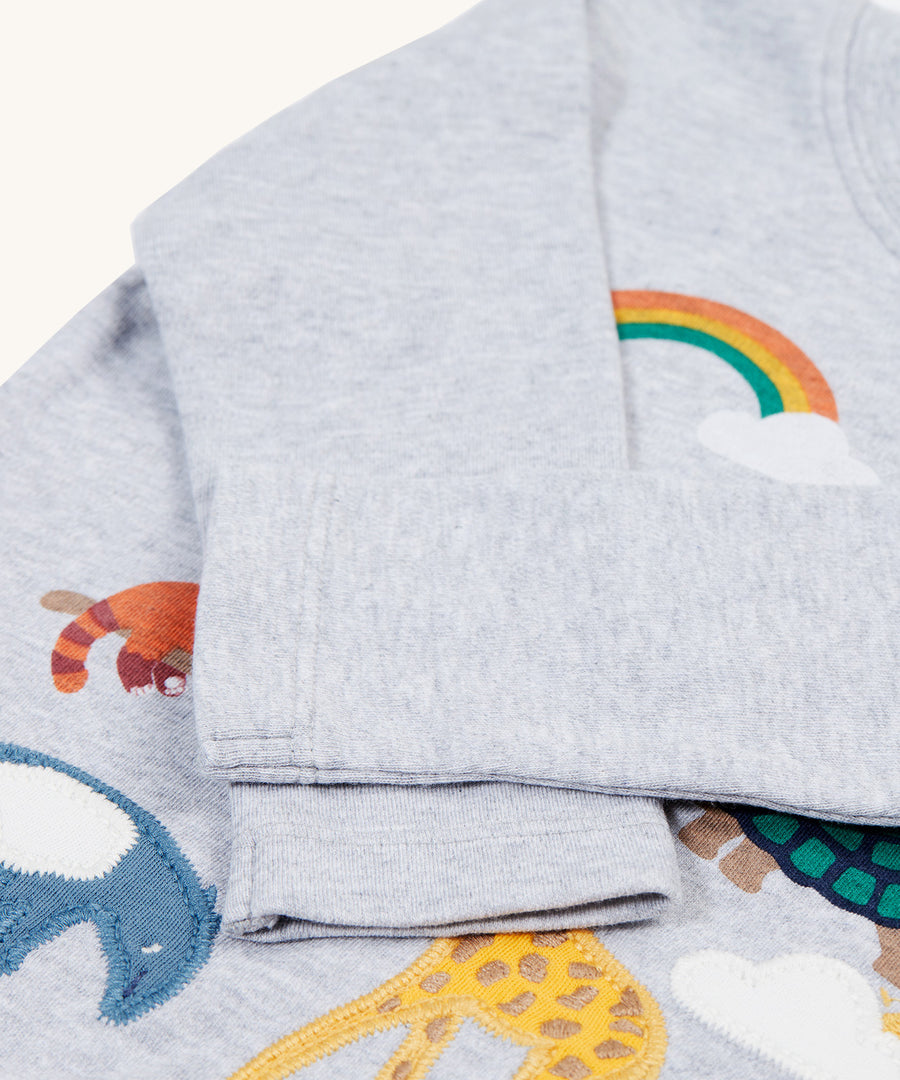 The long, soft sleeves on the Frugi Adventure Applique Top - Grey Marl/Go Wild Animals. Some of the animal applique's are showing under the folded arms of the top