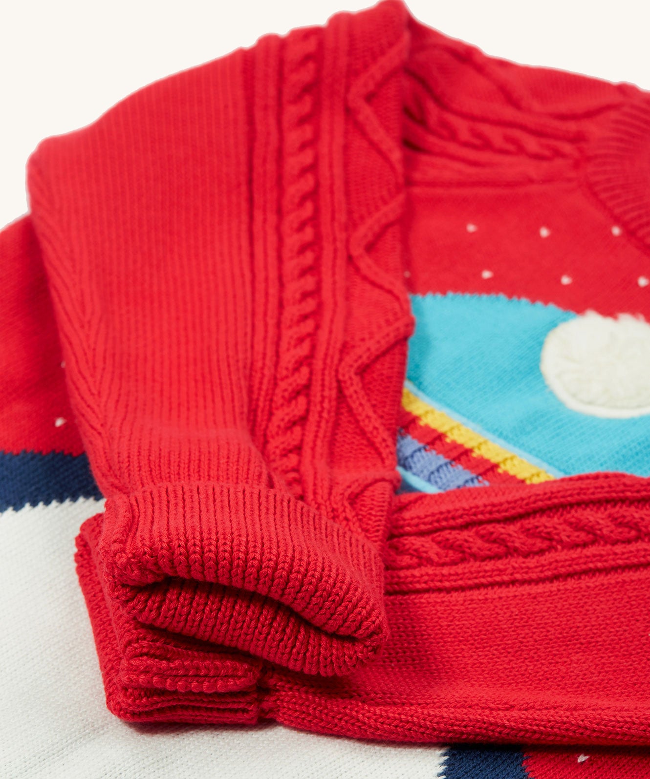 A closer look at the fold over cuffs and cable knit sleeves on the Caleb Character Knit Jumper - True Red/Penguin