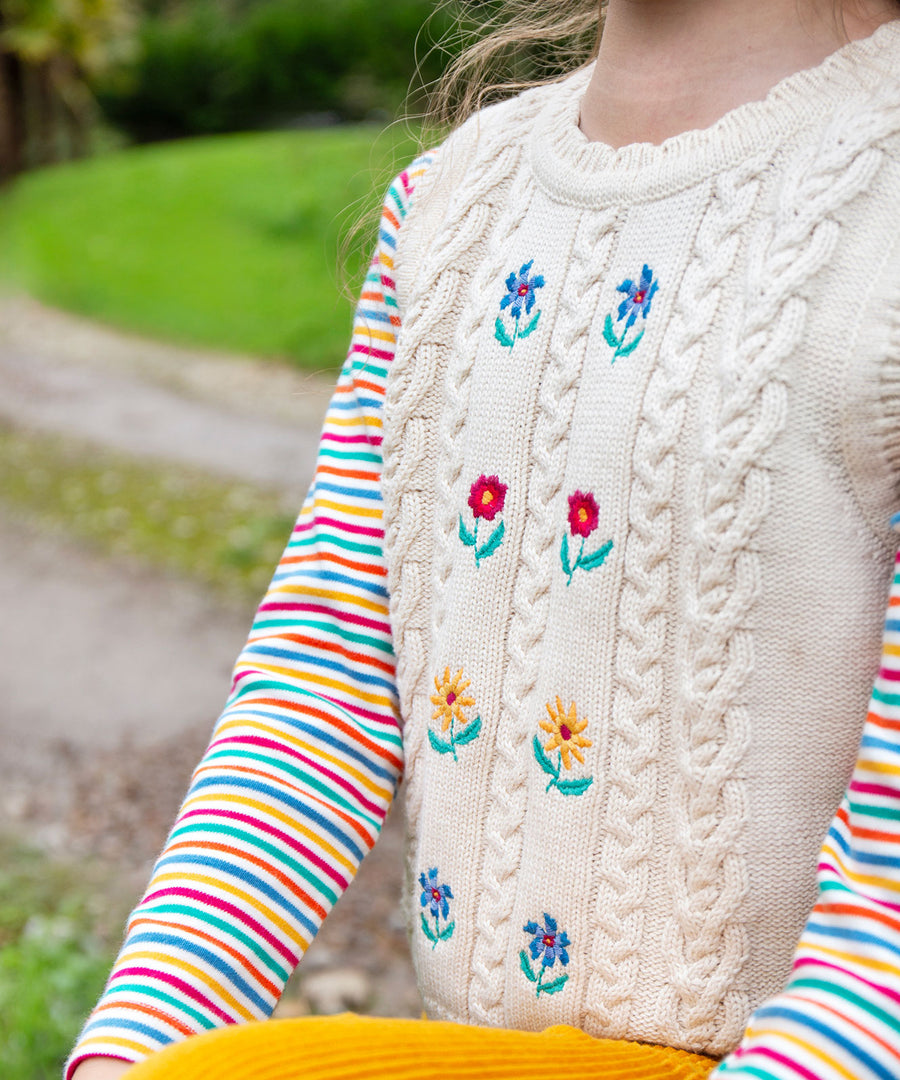 A child wearing the Frugi Marnie Embroidered Tank Top - Pearl/Flowers, showing the flowers at the front