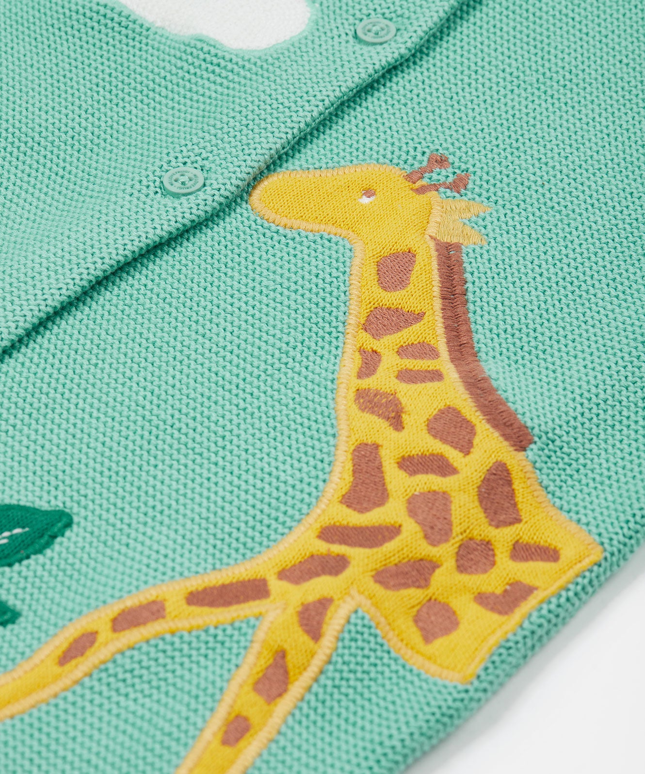 A closer look at the giraffe applique on the Frugi Colby Cardigan - Moss/Giraffe