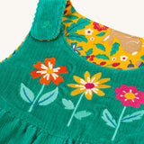 A closer look at the green cord side of the Frugi Lacey Reversible Dungaree - Iguana/Autumn Friends. Showing the popper shoulder straps, and flower applique details on the front