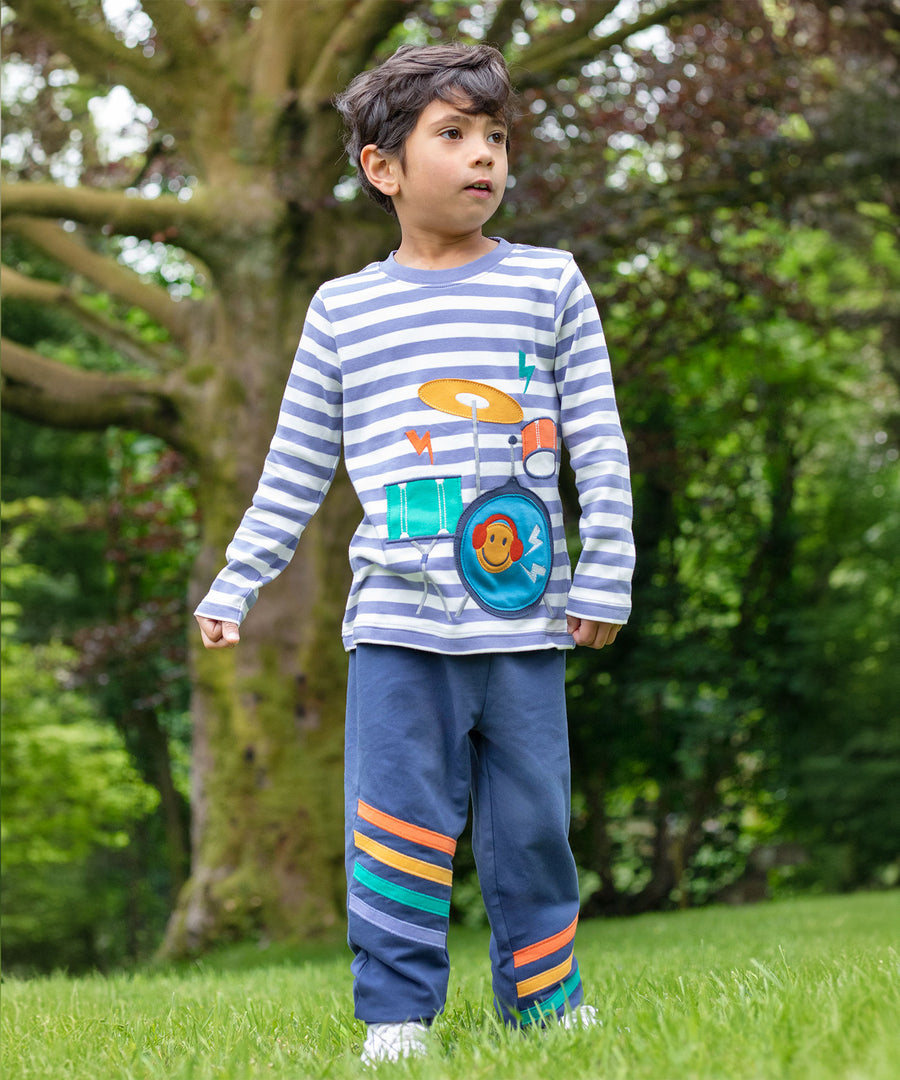 A child outside, wearing the Frugi Perrin Parsnip Jogger - Navy Blue/Stripe and a Frugi top