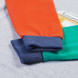 The colour block sleeves and cuffs in orange, green and navy, on the Frugi Jamie Jim Jams - Iguana Stripe/Camper