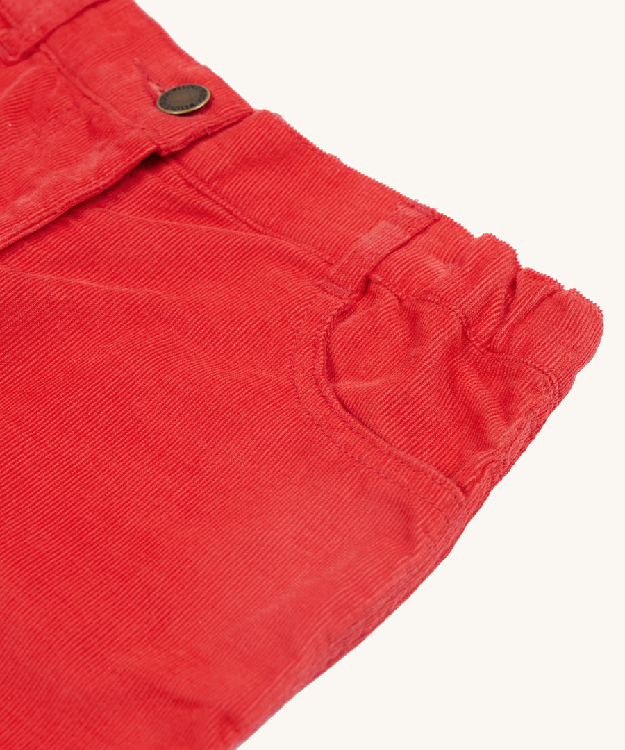 A closer look at the mock button and front pocket on the Frugi Clover Slim Cord Trousers - True Red