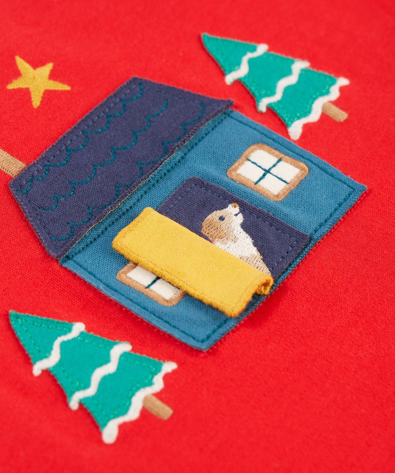 The open yellow door on the home applique. A dog is peeking from inside the door