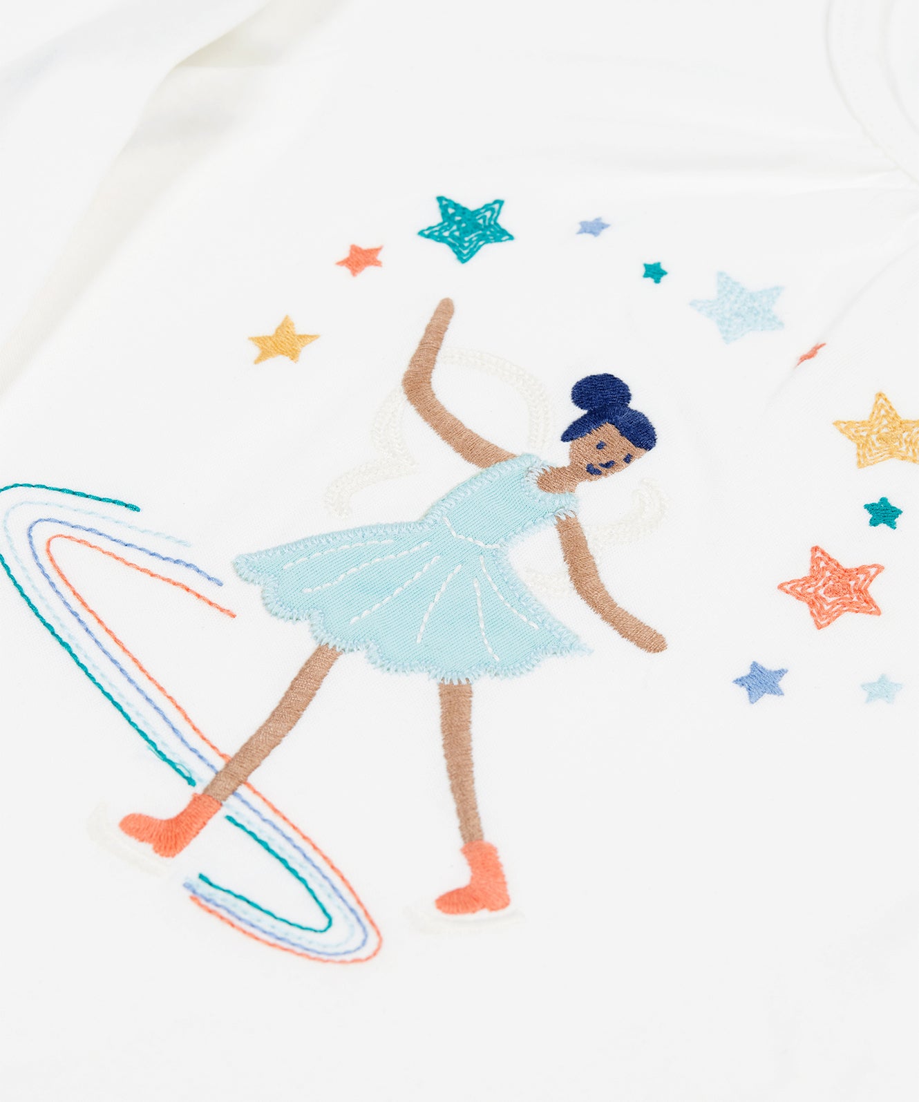 A closer look at the skating fairy in a light blue dress and star applique on the top of the Frugi Alana Pyjamas - Glacier Enchanted Forest/Skater