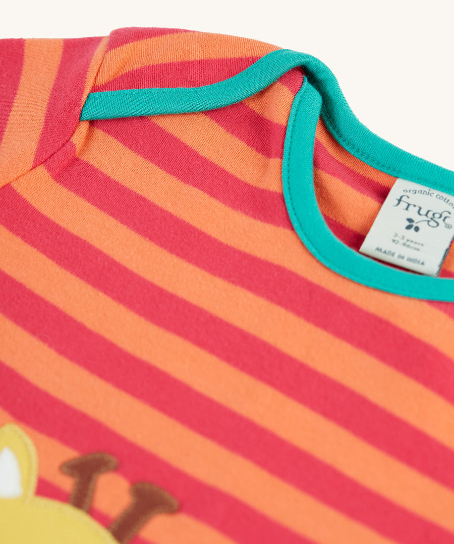 A closer look at the stripes and light green piping on the shoulders and neck area of the Frugi Bobby Applique Top - Cantaloupe Stripe/Giraffe