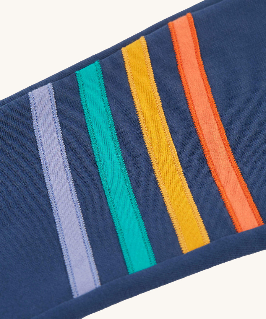 A look at the colourful stripes on the legs of the Frugi Perrin Parsnip Jogger - Navy Blue/Stripe