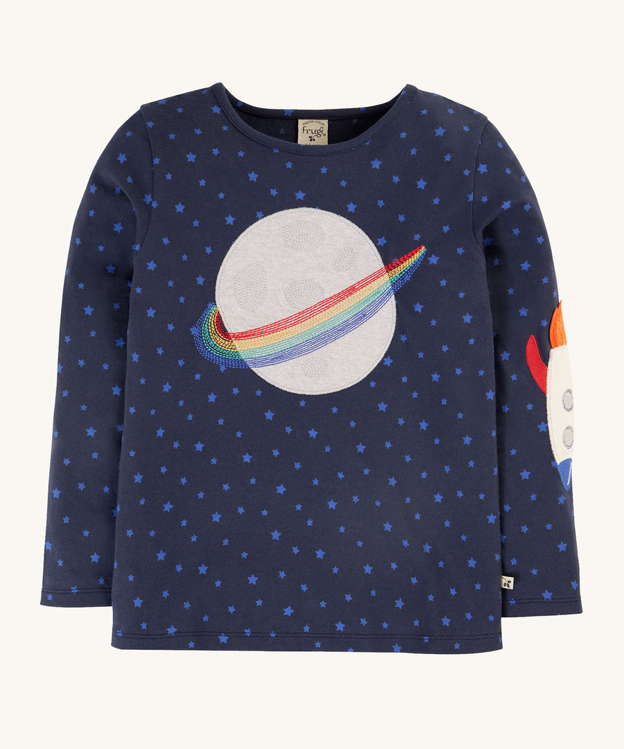 Frugi Tully Applique Top - Starry Night/Planet. A gorgeous, deep, navy lue top with light blue star print, and a planet applique on the chest with rainbow embroidered rings. Also shown is a section of the applique rocket on the sleeve of he top