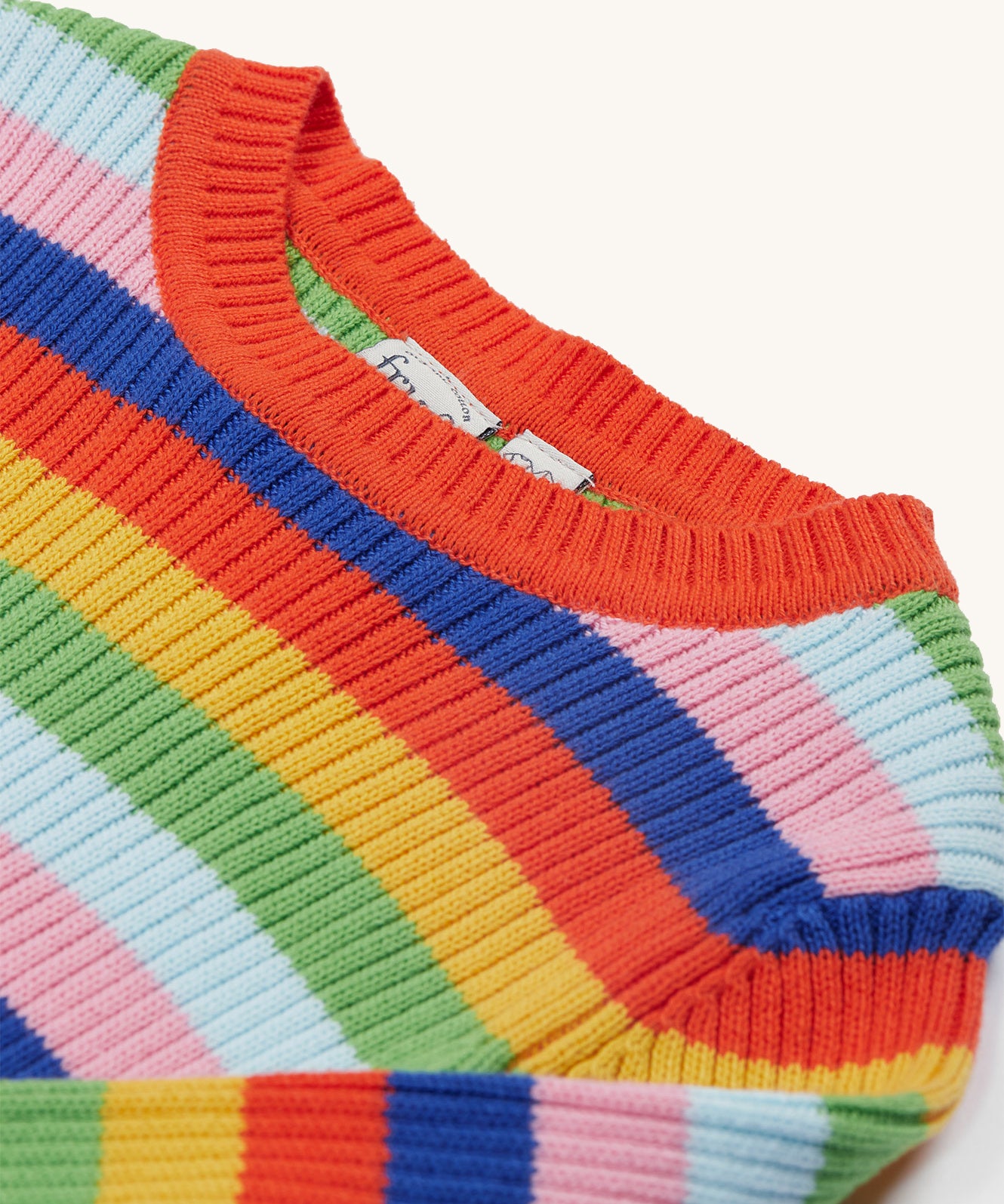 A closer look at the detailed stitching on the neck line of the Frugi Zoe Knitted Jumper - Retro Stripe. Also shown is the colourful, bold colour-block print