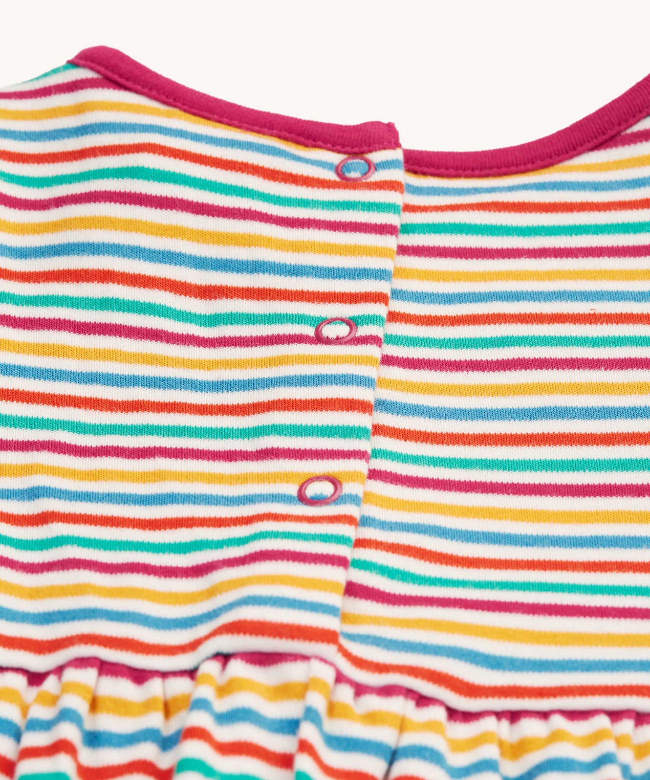 A look at the popper fasteners on the back of the Frugi Dolcie Dress - Lingonberry Multi-Stripe