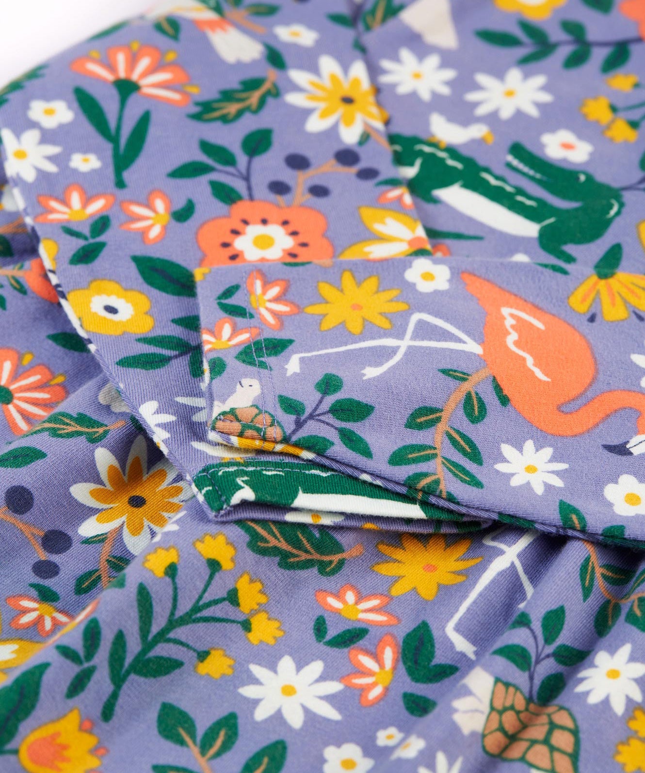 The long sleeves on the Frugi Dee Dress - Rainforest Friends, in the Rainforest Friends print, on lilac fabric