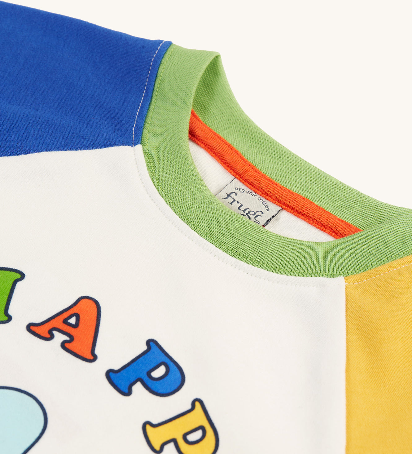 A closer look at the green collar and the tops of the sleeves on the Frugi Tamar Raglan Top - Soft White/Bee Happy. The Bee and Bee Happy print can be slightly seen at the bottom of the image