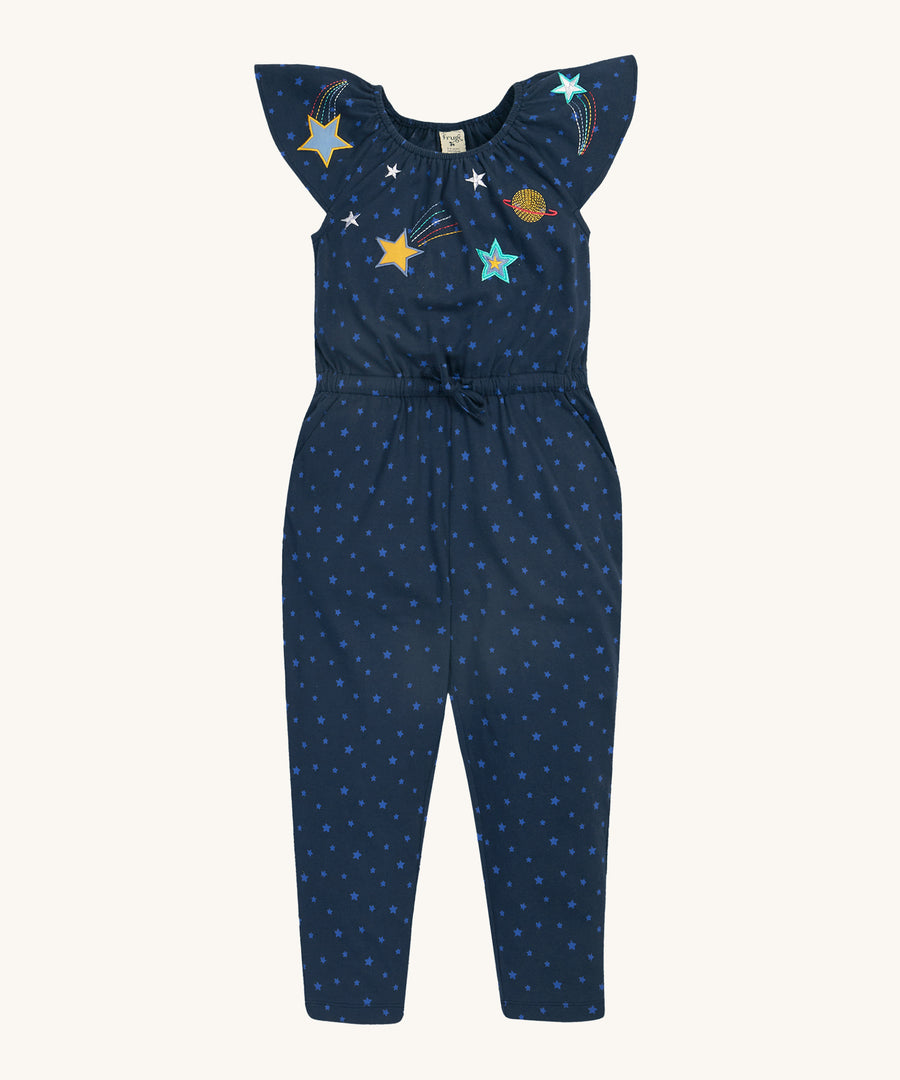 Frugi Lorena Jumpsuit - Starry Night/Space. A beautiful, deep, navy blue jump suit with light blue stars all over, made from organic cotton. The jumpsuit also has a drawcord and elasticated waist, capped shoulder sleeves and beautiful printed stars and planets on the top part of the chest and sleeves