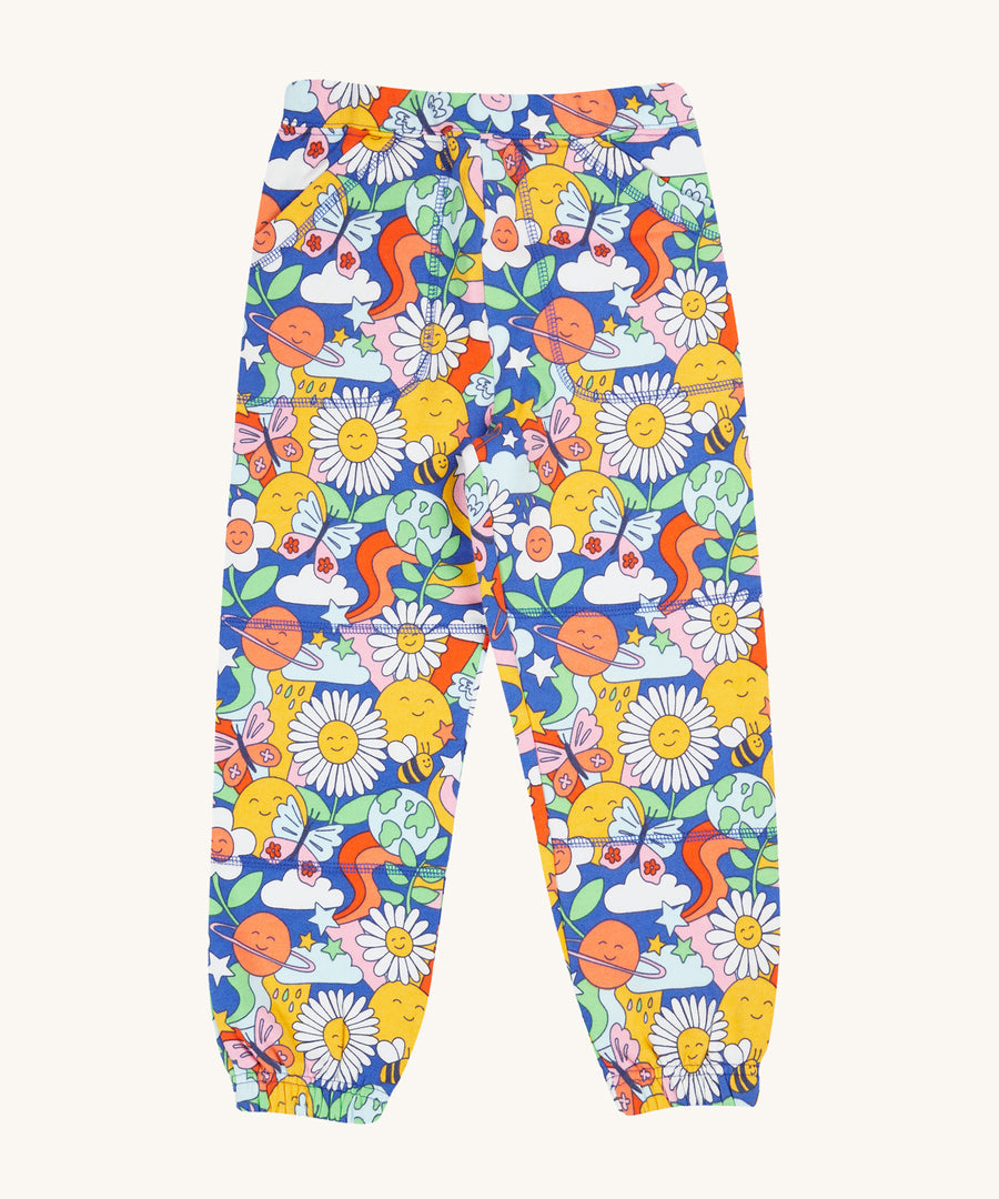 Frugi Malpas Joggers - Retro Happy. A fun and colourful pair of joggers in the retro happy print, with pockets, an elasticated waistband and elasticated ankle cuffs. The Retro Happy print includes smiling faces and planets, stars, bees, clouds, rainbows and butterflies.