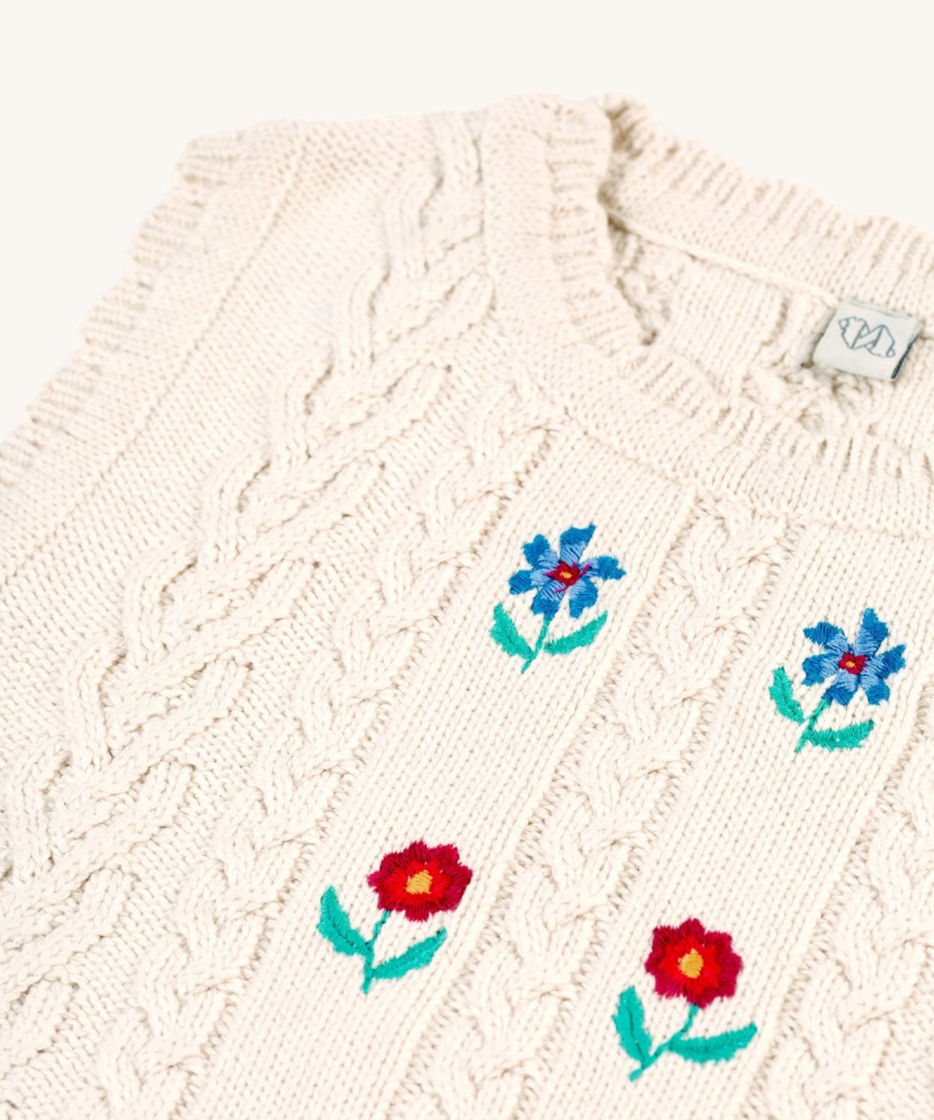 A closer look at the knitted detail and embroidered flowers on the Frugi Marnie Embroidered Tank Top - Pearl/Flowers