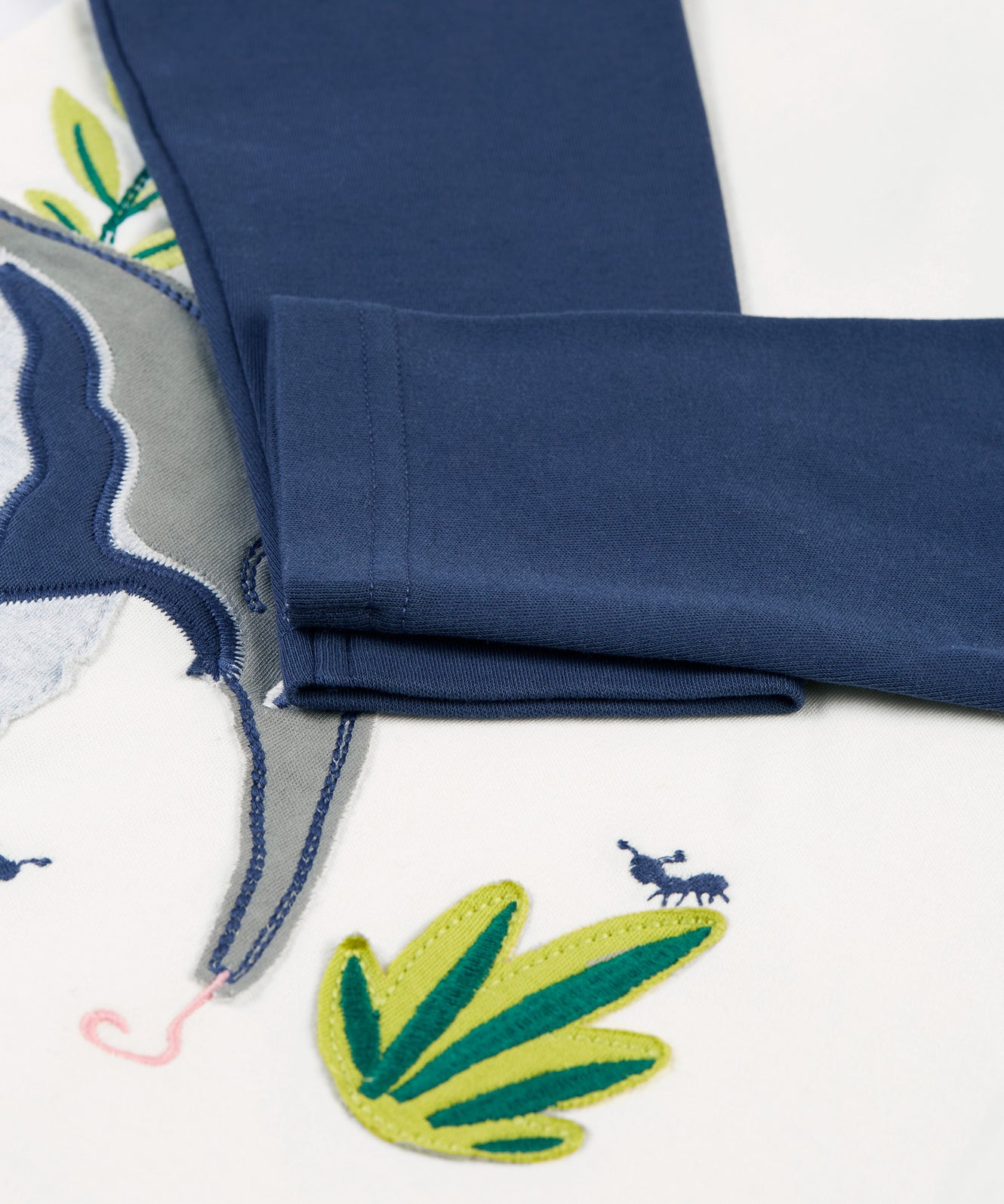 A closer look at the navy blue sleeves on the Frugi Alfie Raglan Top - Navy Blue/Anteater, with the anteater applique showing partially underneath