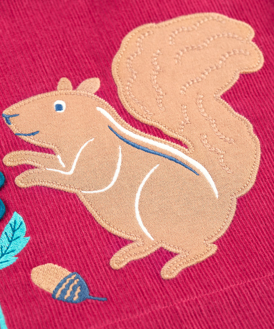 A closer look at the squirrel applique detail on the Frugi Coco Cord Dress - Lingonberry/Squirrel