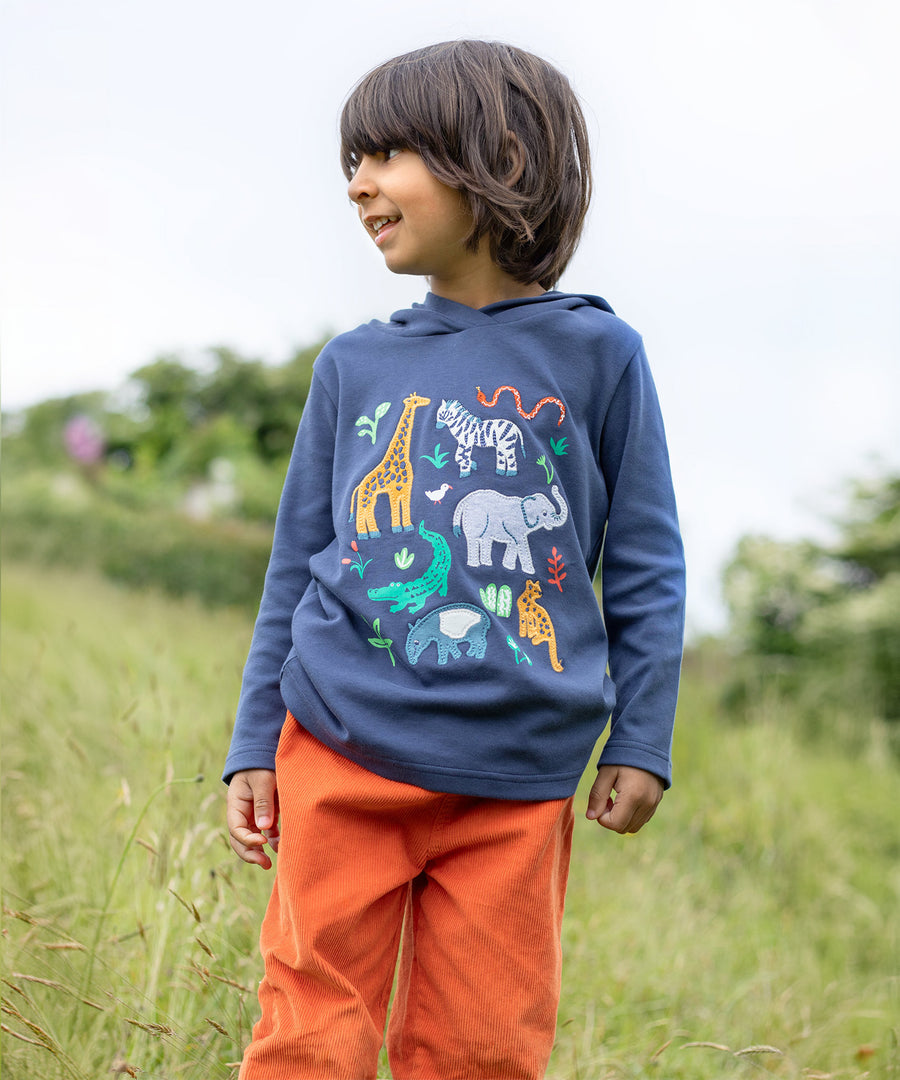 A child outside, wearing the Frugi Campfire Hooded Top - Navy Blue/Go Wild Animals and orange Frugi cord trousers