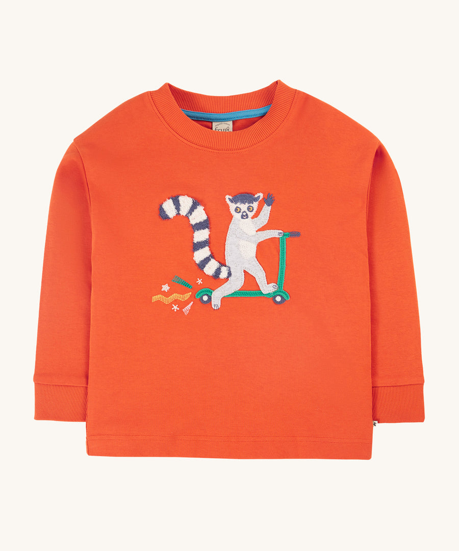 Frugi Owen Top - Bonfire/Lemur. A bold orange top with a funny lemur riding a scooter