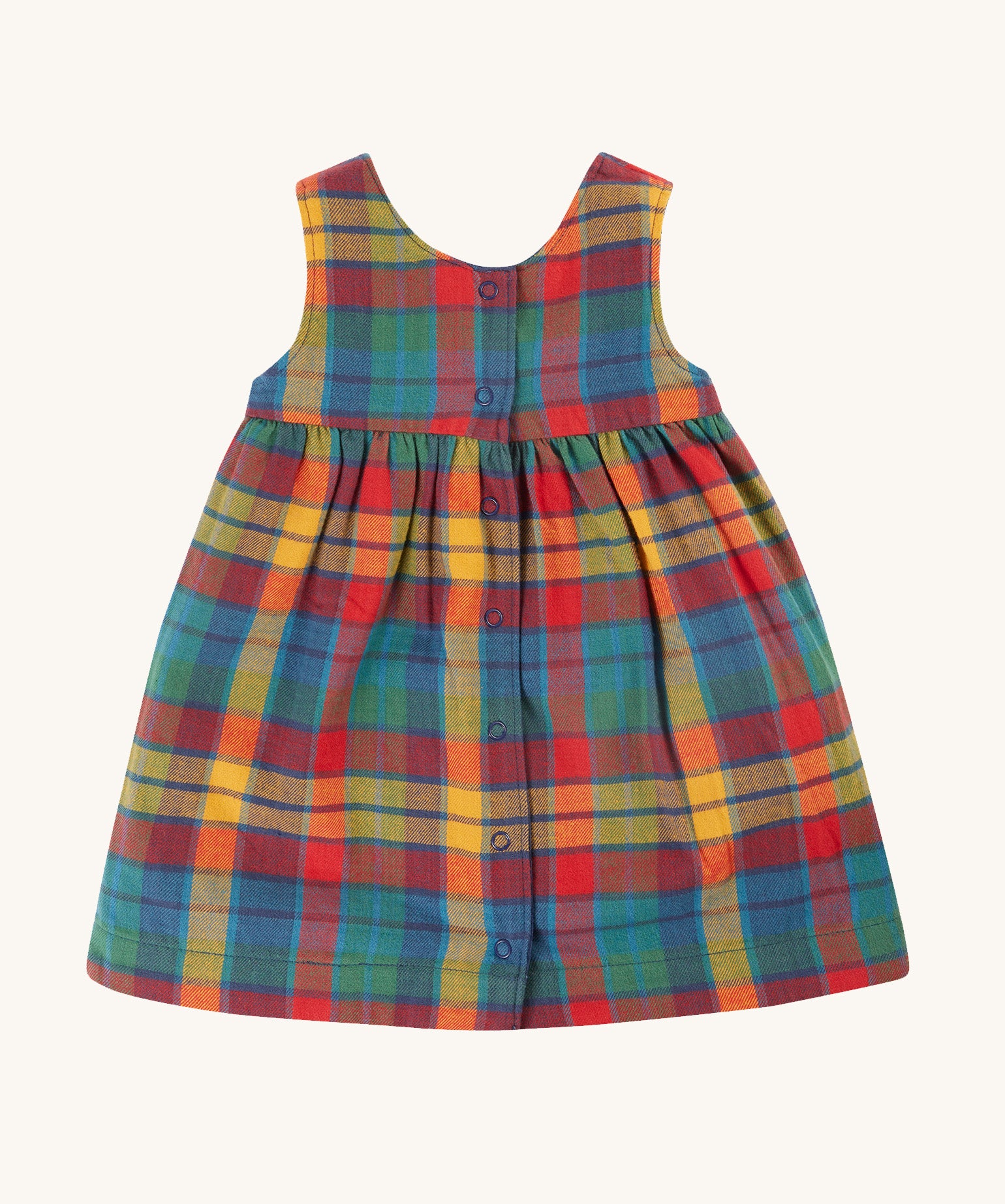 The rainbow check side of the Frugi Inara Cord Reversible Dress - Navy Blue/Rainbow Check, in various shades of red, blue, green and yellow. The image also shows the popper fasteners down the middle of the dress at the back