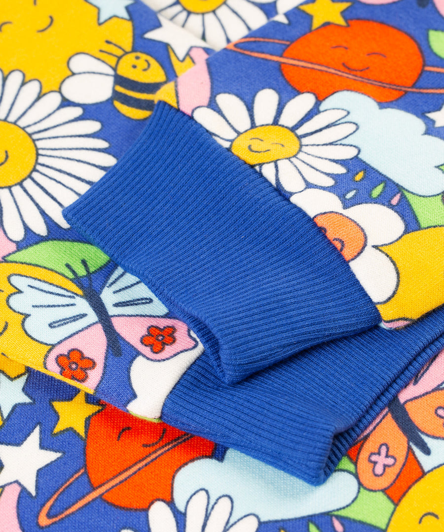 A closer look at the royal blue,  elasticated ribbed cuffs on the Frugi Superb Sweatshirt - Retro Happy. The image also shows a close up of the Retro Happy print