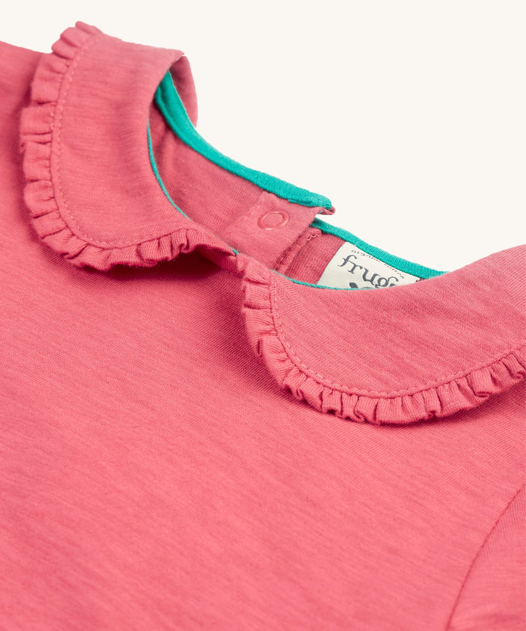 A closer look at the ruffled collar on the Frugi Victoria Collared Tunic Top - Petal/Cat