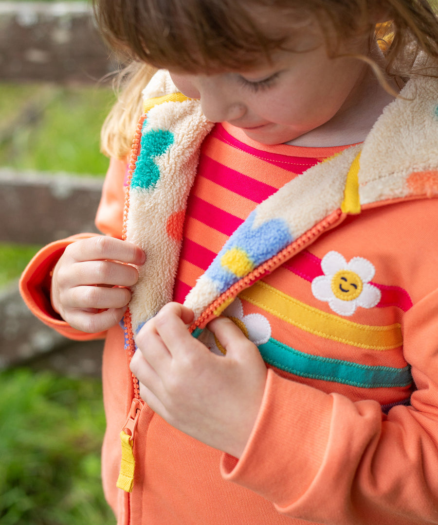 A child looking down at the flower pop fleece inside the jacket