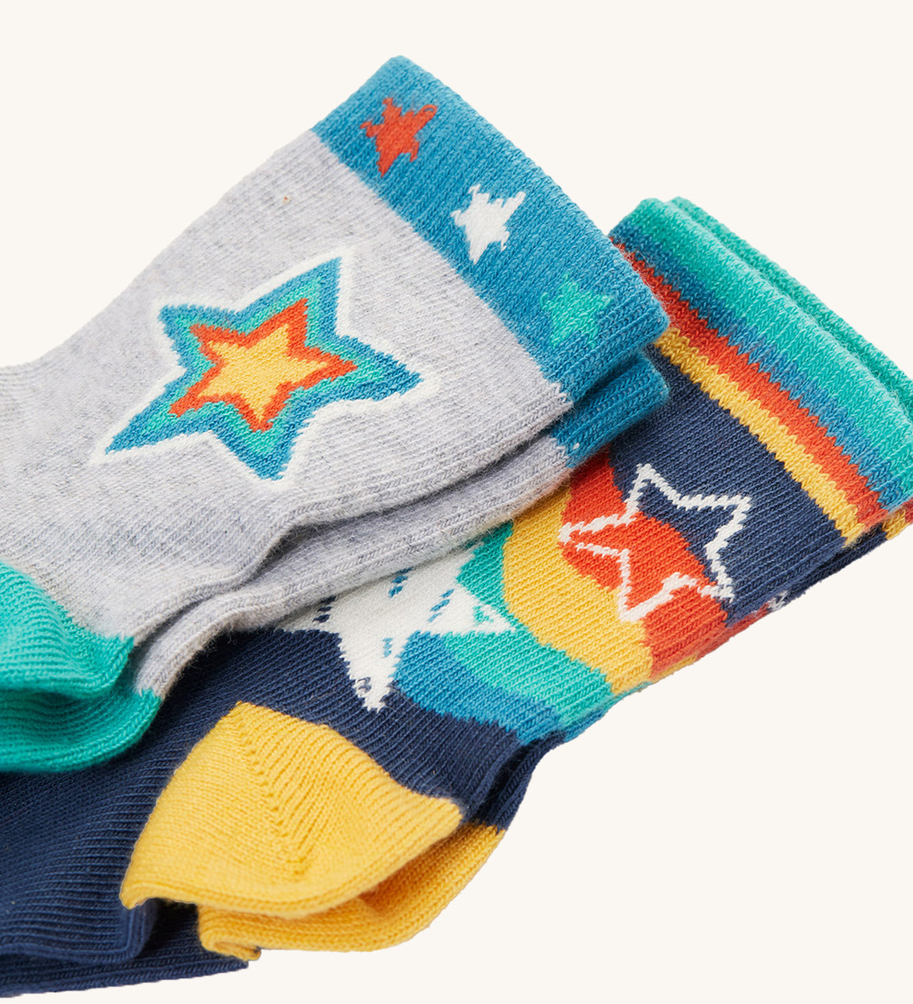 Both pairs of Frugi Little Socks - Stars 2 Pack. The grey pair is on top, with the navy pair below