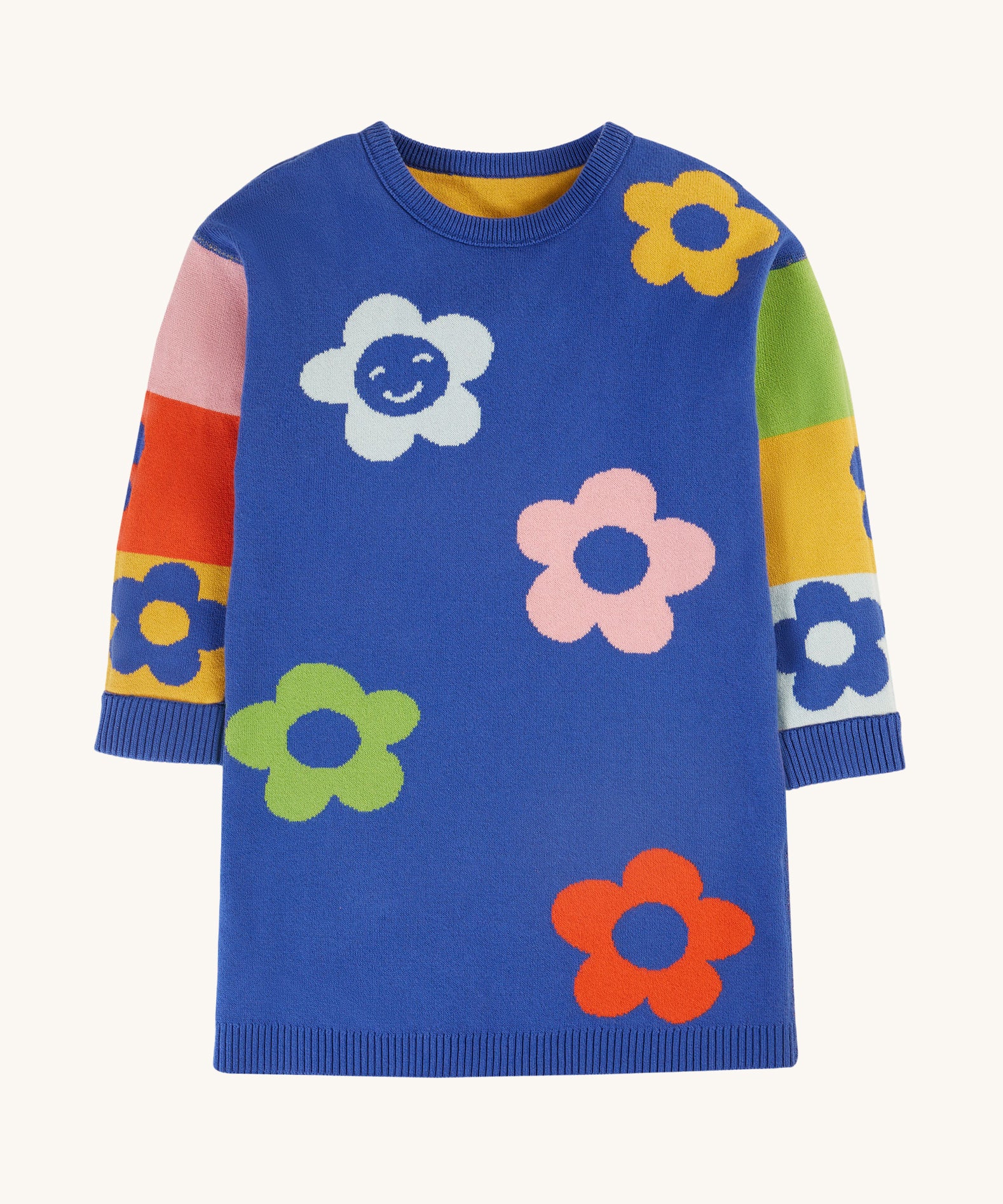 The blue body and colour-block side of the Frugi Zola Reversible Knitted Dress - Blue Tang/Retro Floral. A soft, royal blue, organic cotton knit dress, with colour-block sleeves in yellow, red, green, pink and light blue colour, and colourful bold flower prints 